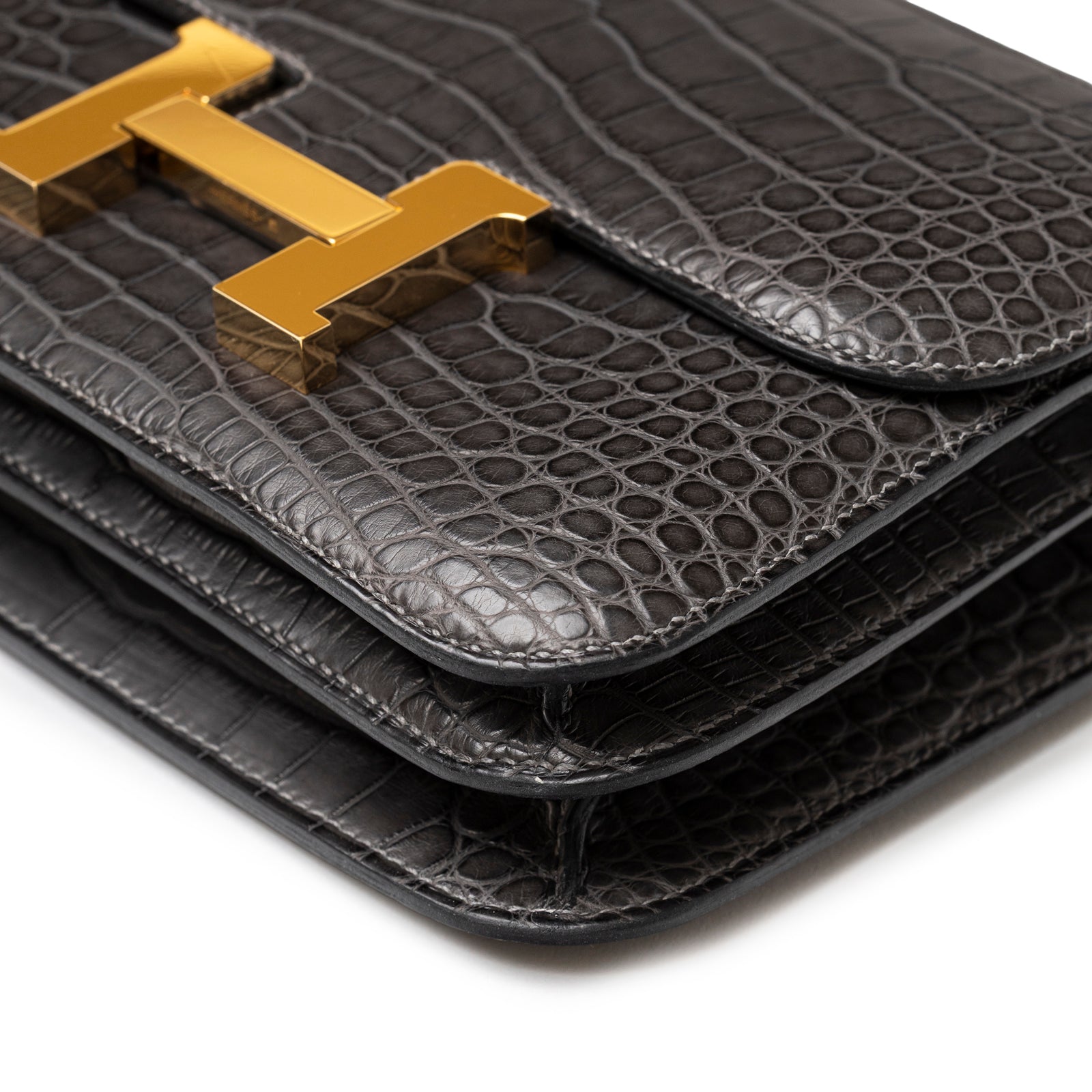 Close-up of Hermès Mini Constance 18 Graphite Matte Alligator Gold Hardware flap edges and textured leather grain detail