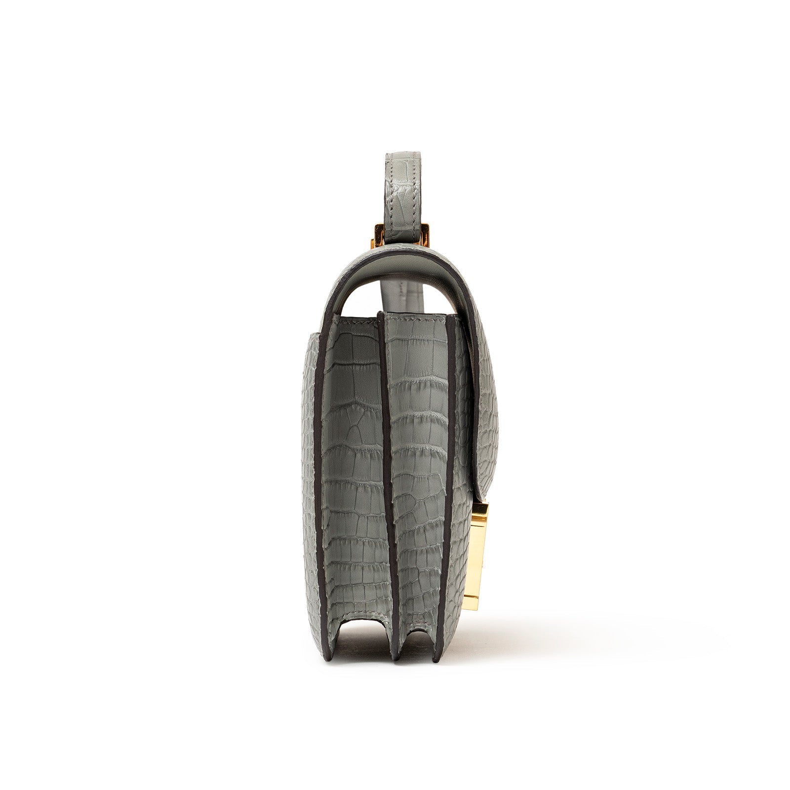Side view of Hermès Mini Constance 18 Gris Ciment Matte Alligator Gold Hardware showing its slim profile and stitching details