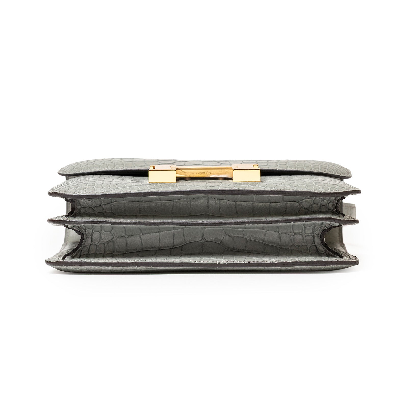 Bottom view of Hermès Mini Constance 18 Gris Ciment Matte Alligator Gold Hardware showing layered compartments and texture details