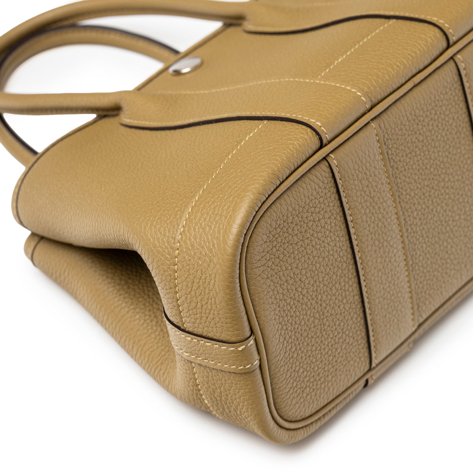 Close-up angled view of structured taupe leather base and stitched edges on Hermès Mini Garden Party Neo 23 Dune Negonda Palladium Hardware