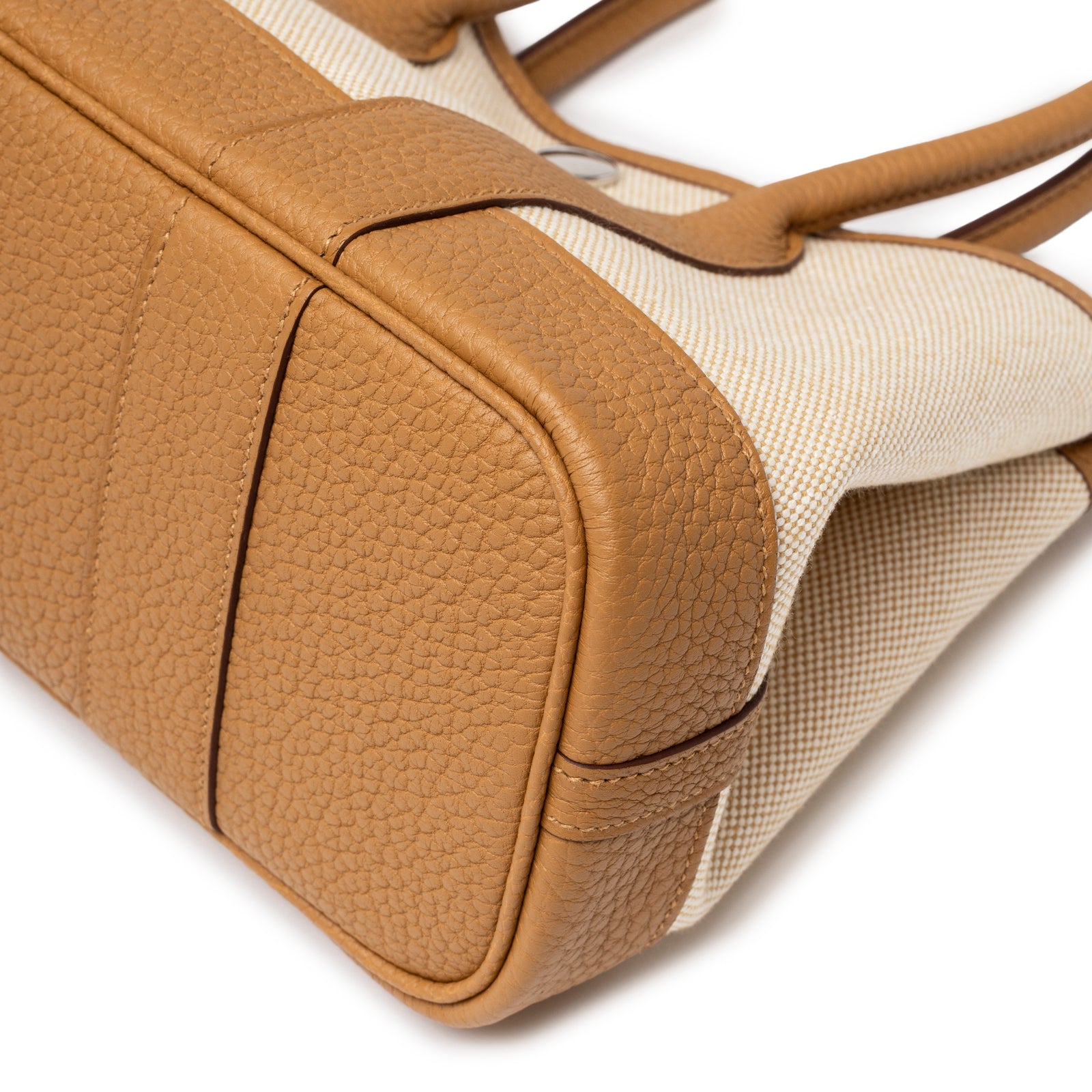 Close-up of bottom corner showing textured leather and canvas on Hermès Mini Garden Party Neo 23 Ecru-Paille Toile H Canvas and Sesame Negonda Palladium Hardware