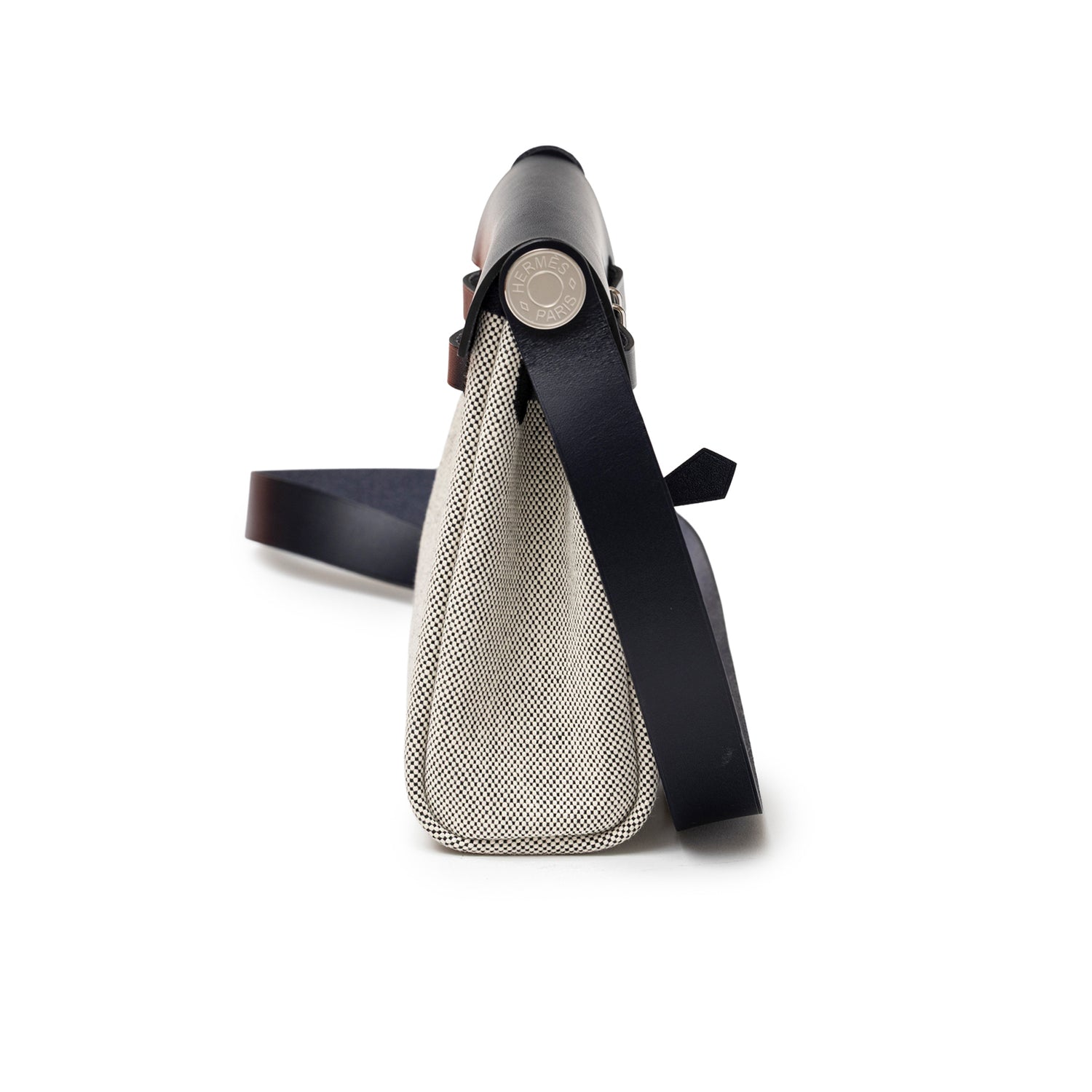 Side view of Hermès Mini Herbag Zip 20 Ecru-Black Blue Indigo Toile and Vache Hunter Palladium Hardware showing slim profile and strap detail