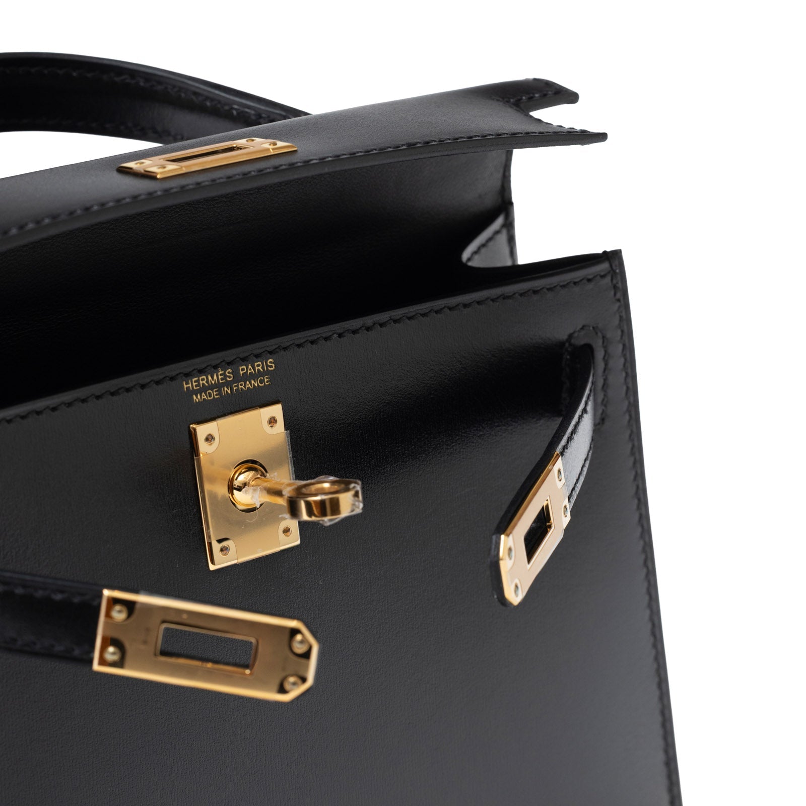 Close-up angled view of Hermès Mini Kelly II Sellier 20 Black Box Gold Hardware showing locking clasp detail