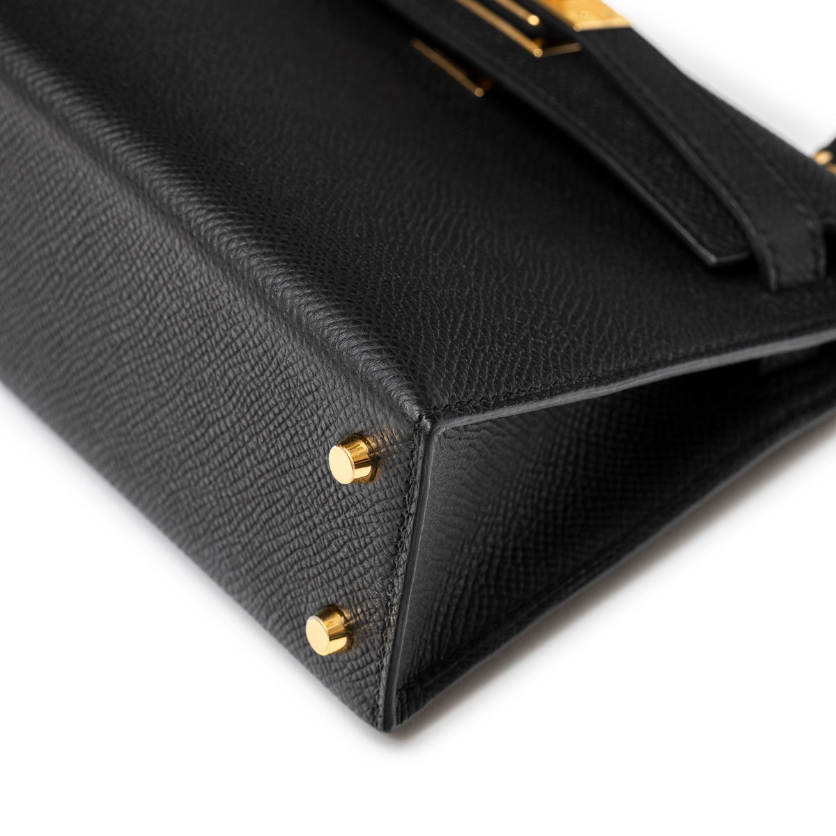 Close-up of bottom corner on Hermès Mini Kelly II Sellier 20 Black Epsom Gold Hardware showing gold feet and leather grain detail