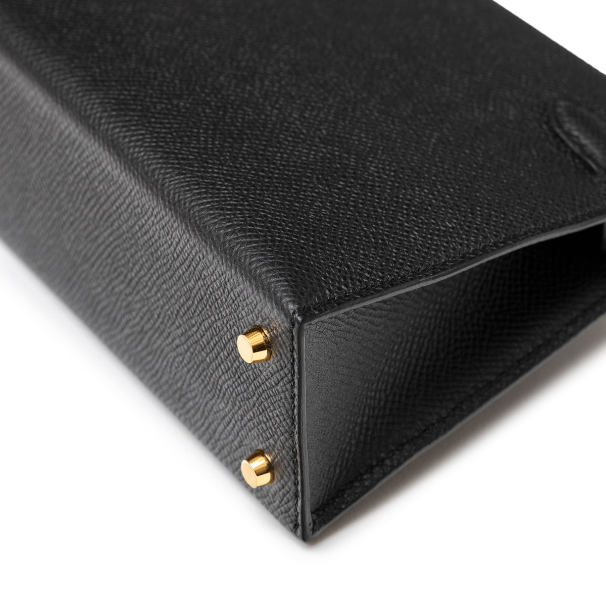 Close-up of base corner on Hermès Mini Kelly II Sellier 20 Black Epsom Gold Hardware showing gold studs and leather grain detail
