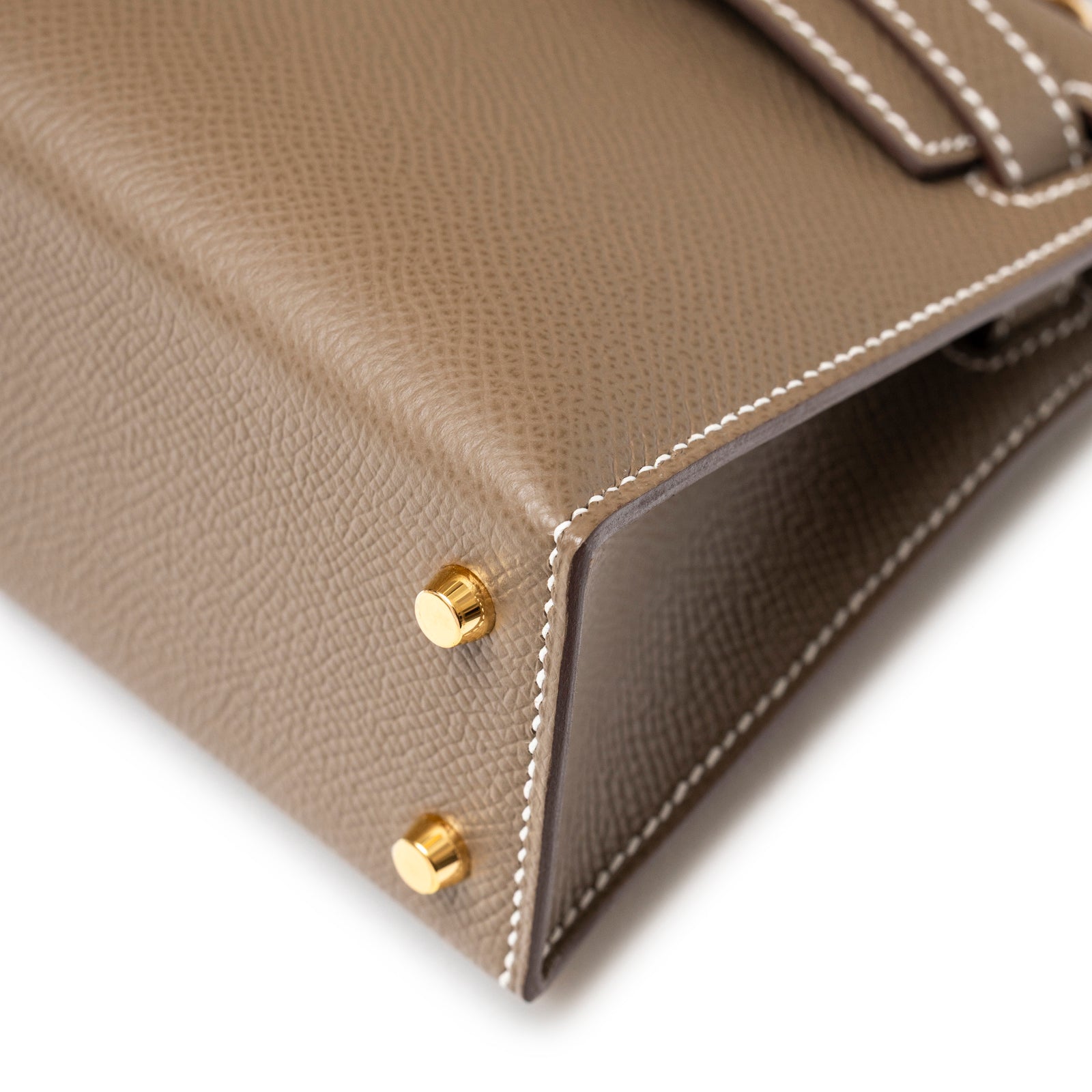 Close-up of Hermès Mini Kelly II Sellier Etoupe Epsom Gold Hardware corner with textured leather and gold studs detail