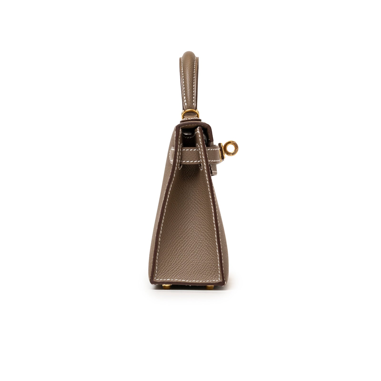 Side view of Hermès Mini Kelly II Sellier Etoupe Epsom Gold Hardware showing structured shape and white stitching