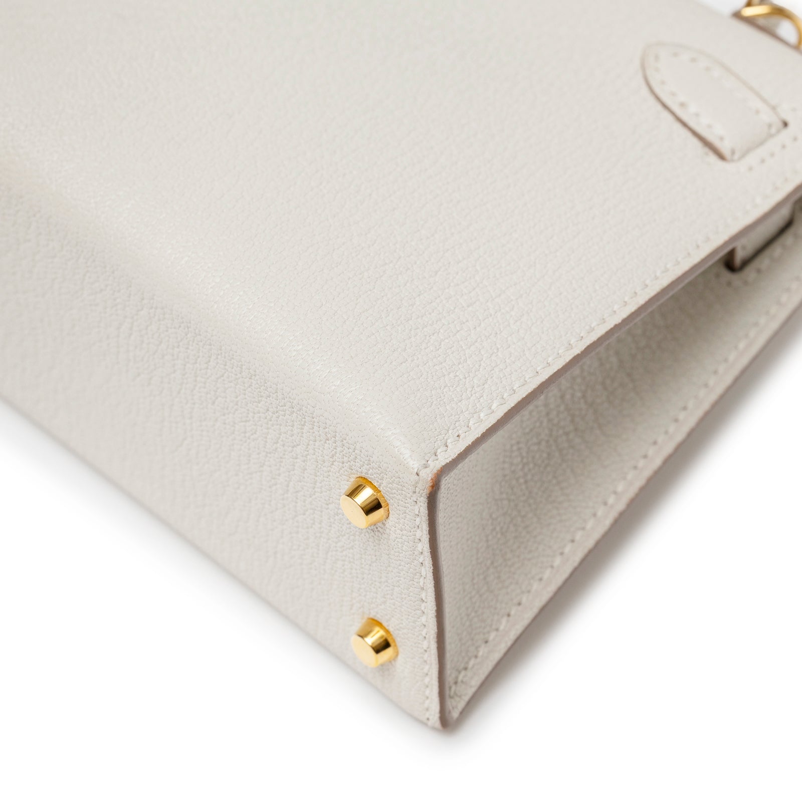Close-up of Hermès Mini Kelly II Sellier Mushroom Chevre Mysore Gold Hardware showing gold protective feet and grain texture