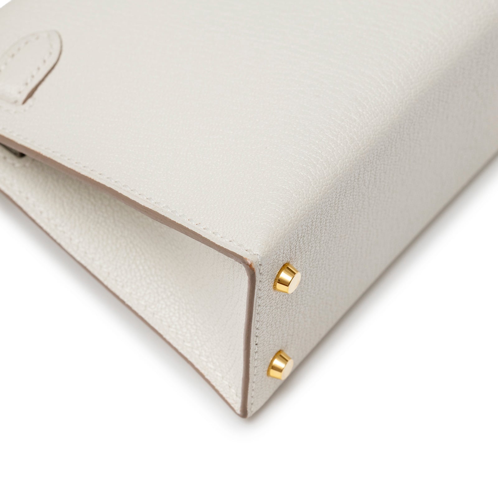 Close-up corner view of Hermès Mini Kelly II Sellier Mushroom Chevre Mysore Gold Hardware showing leather texture and gold studs detail