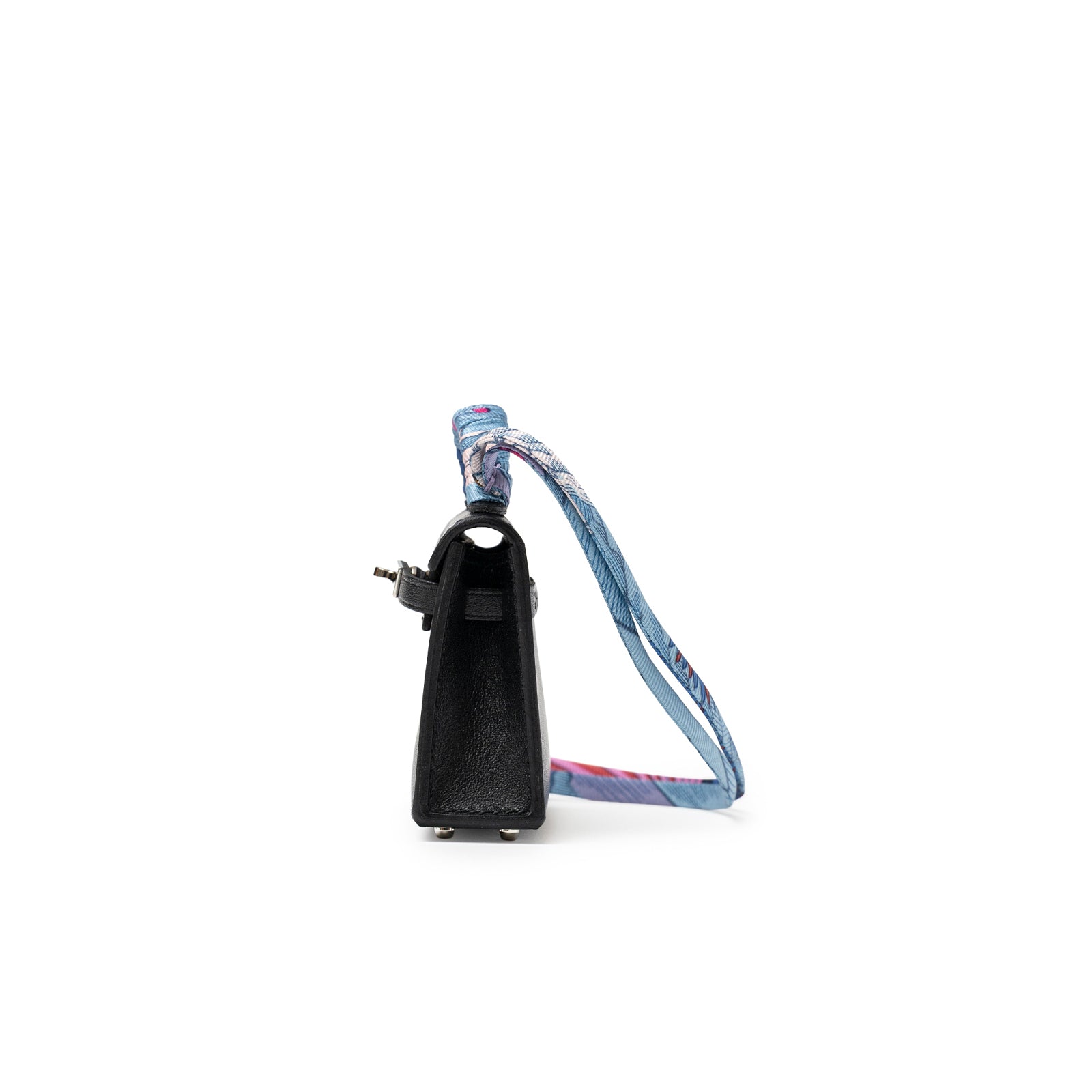 Side view of Hermès Mini Kelly Twilly Bag Charm Black Tadelakt with blue patterned strap and palladium hardware