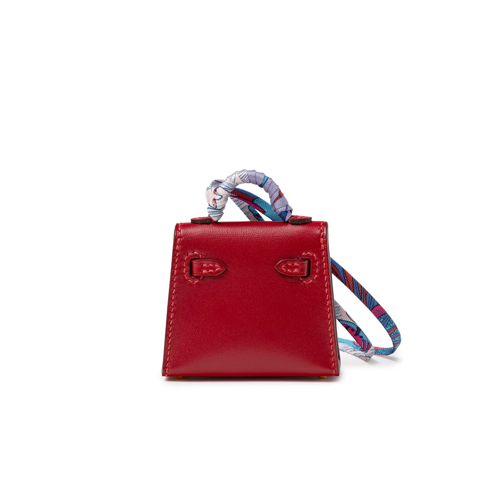 Back view of Hermès Mini Kelly Twilly Bag Charm Rouge Tadelakt Gold Hardware with patterned scarf handle detail