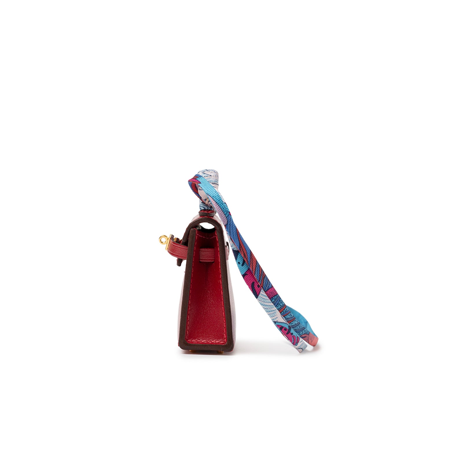 Side view of Hermès Mini Kelly Twilly Bag Charm Rouge Tadelakt Gold Hardware with colorful silk twilly attached