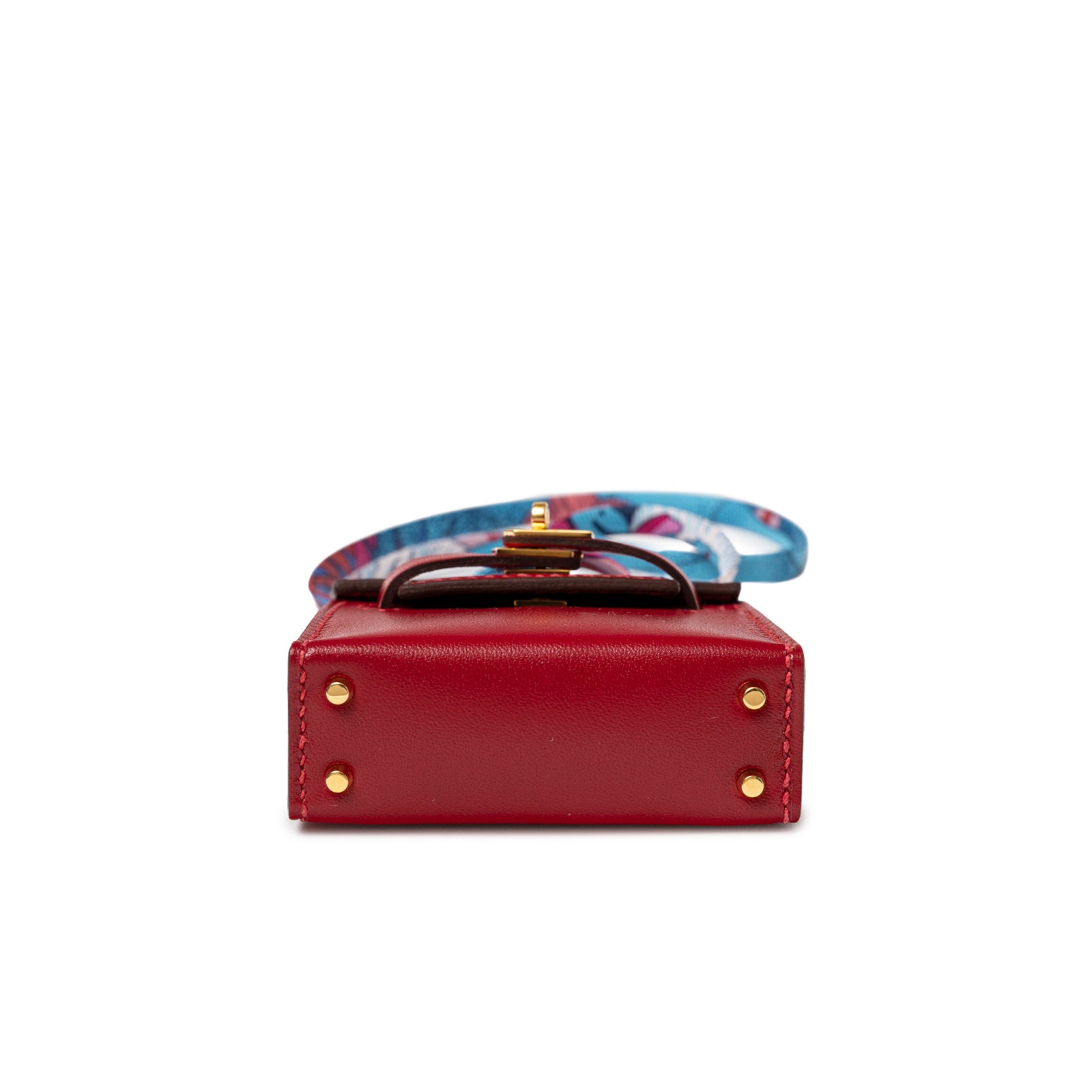 Bottom view of Hermès Mini Kelly Twilly Bag Charm Rouge Tadelakt Gold Hardware with leather and scarf detail