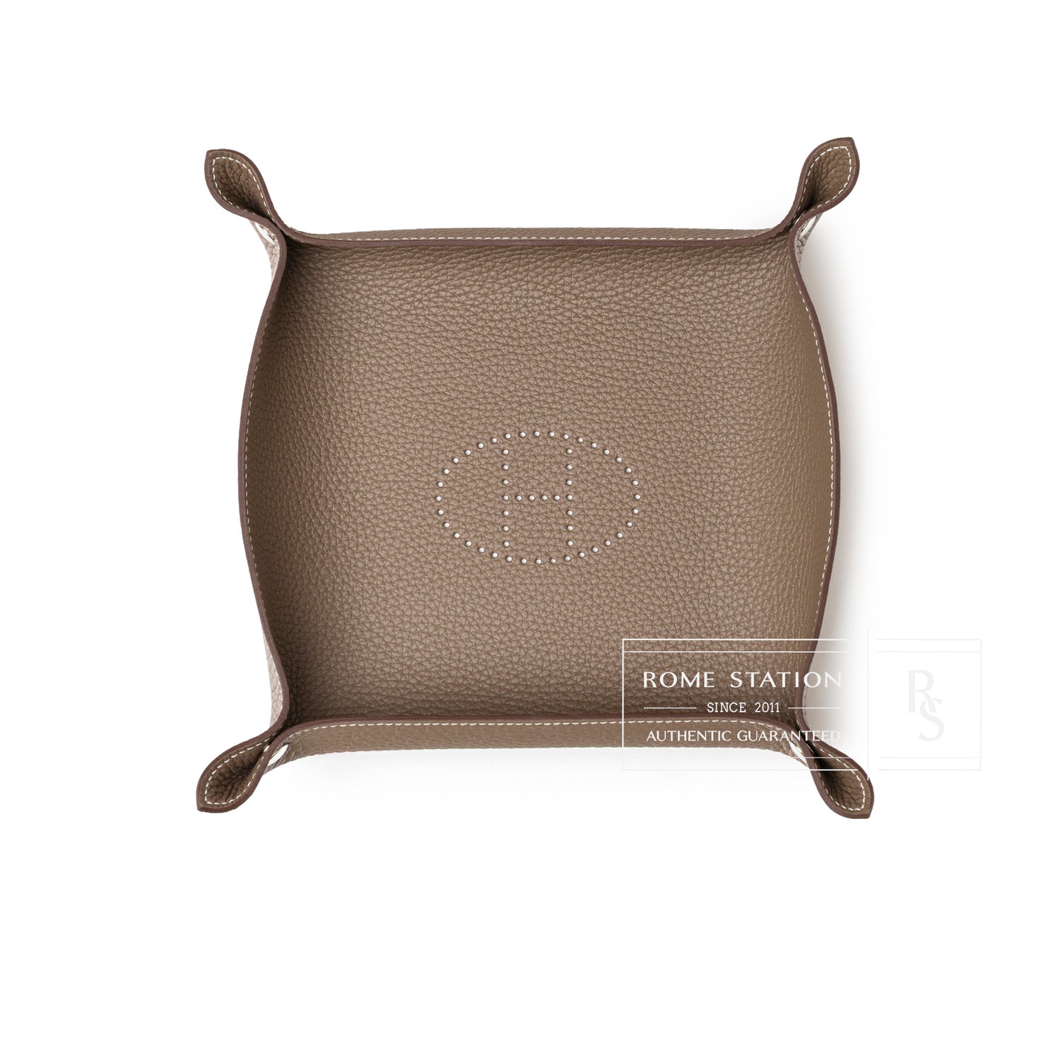 Top-down view of Hermès Mises et Relances H Evelyne Change Tray Etoupe Clemence in textured leather with perforated H logo