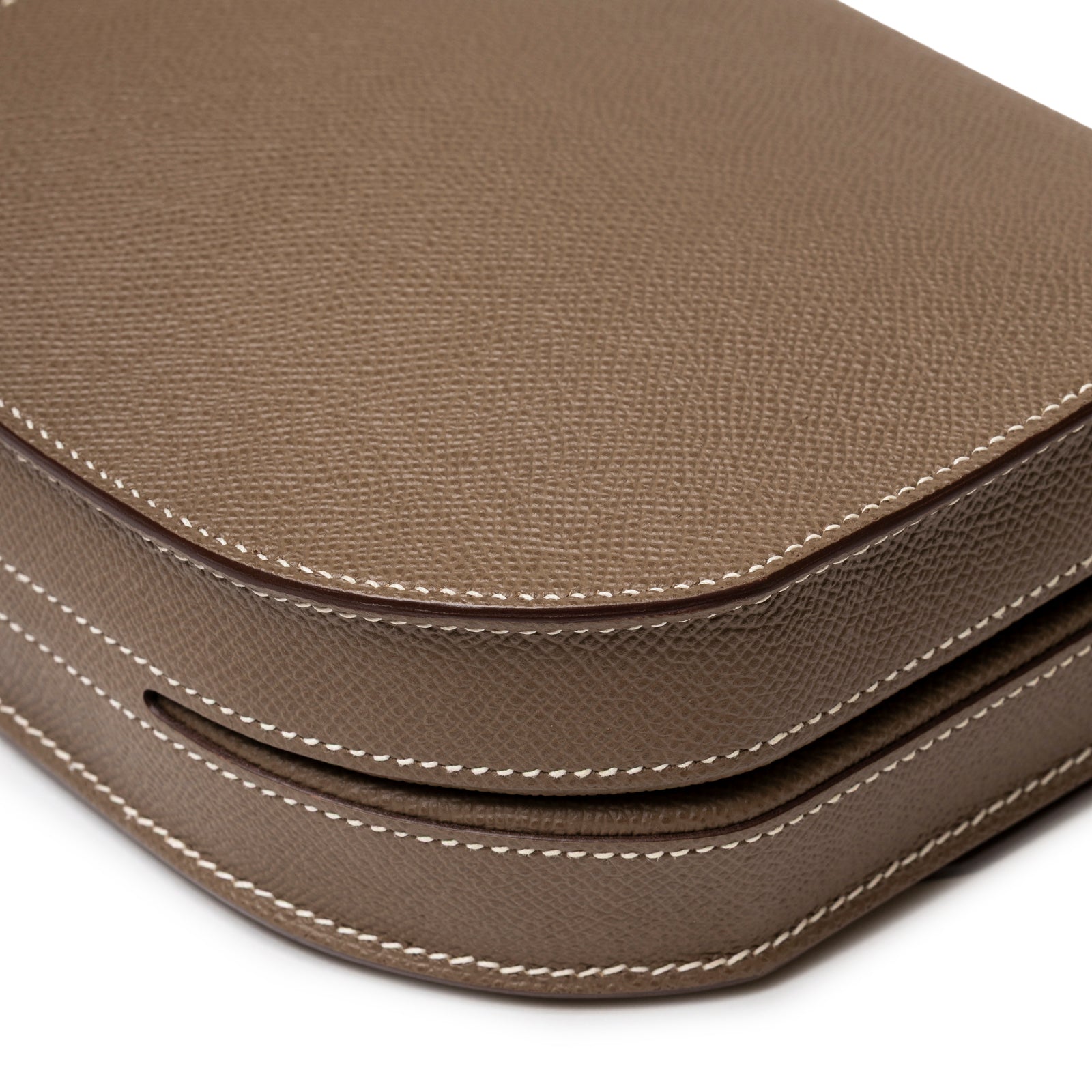 Close-up angled view of Hermès Mosaique Au 24-17 Etoupe Epsom Permabrass Hardware showing leather texture and white stitching detail