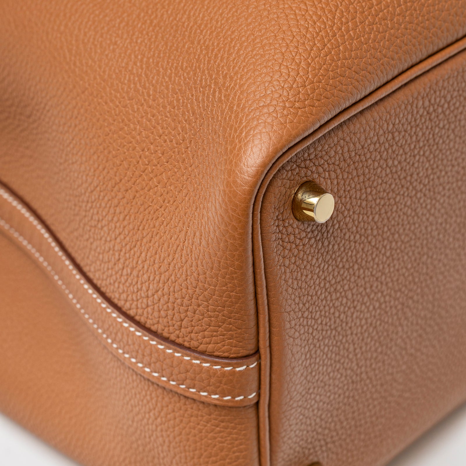 Close-up of Hermès Picotin 18 Gold Clemence Gold Hardware D showcasing leather texture and polished gold footstud detail