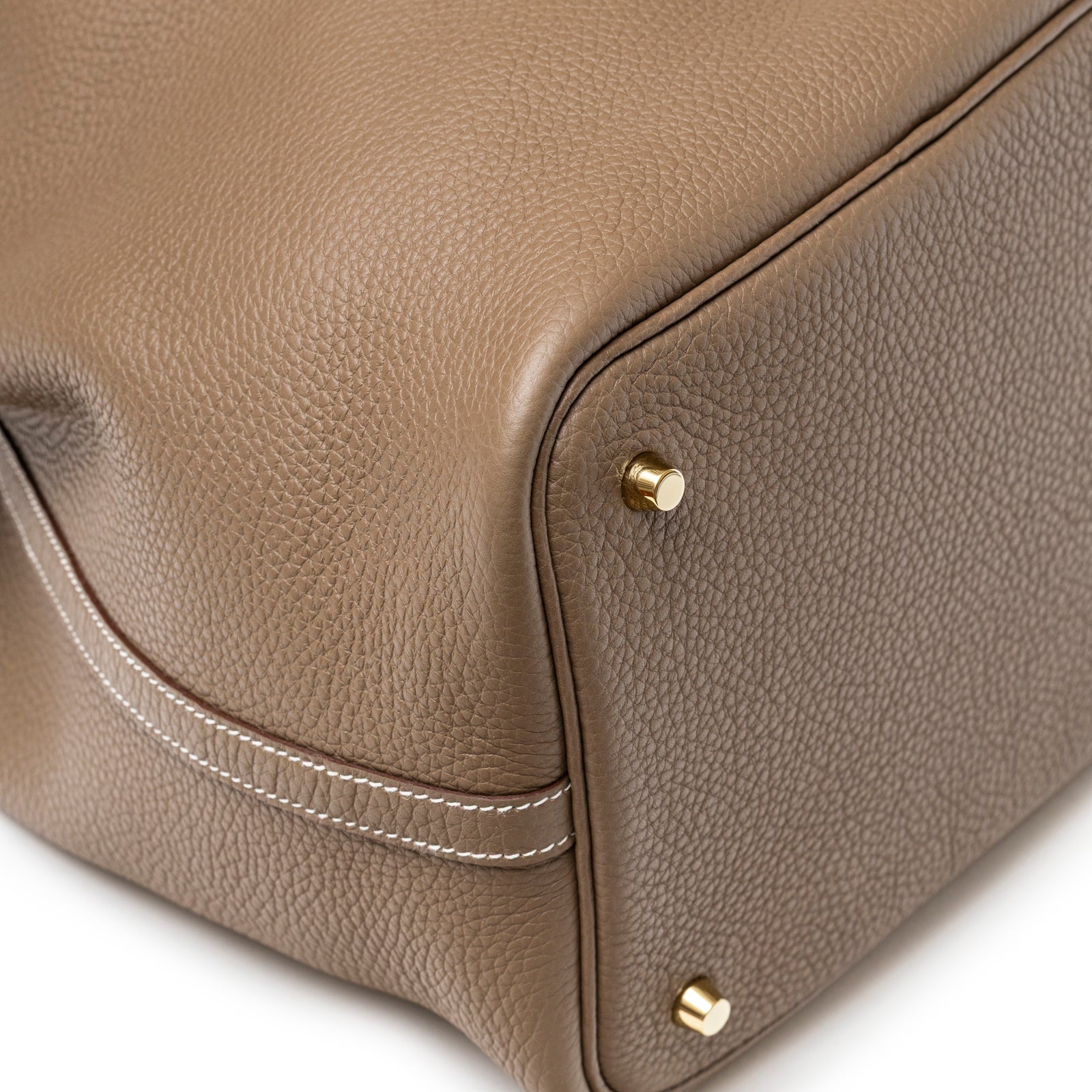 Close-up of bottom corner on Hermès Picotin 22 Etoupe Clemence Gold Hardware showing textured leather and gold feet