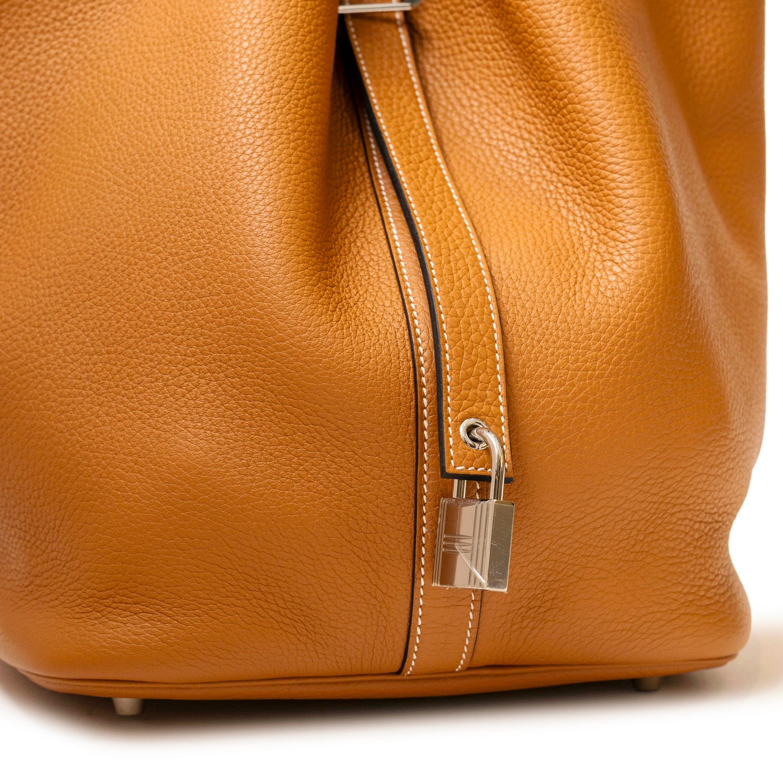 Close-up of Hermès Picotin 26 Toffee Bordeaux Clemence Palladium Hardware showing textured leather and silver lock detail.