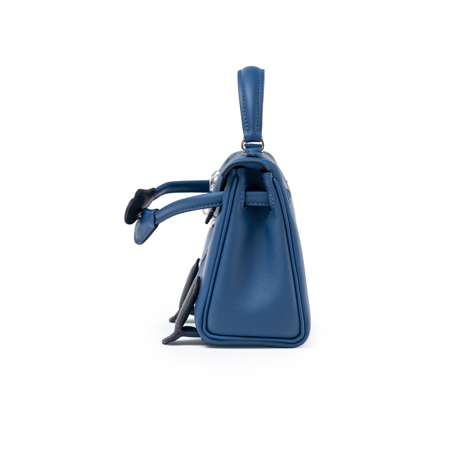 Side view of Hermès Quelle Idolle Kelly Doll Bleu Tie and Caban Swift Palladium Hardware bag showing smooth leather profile