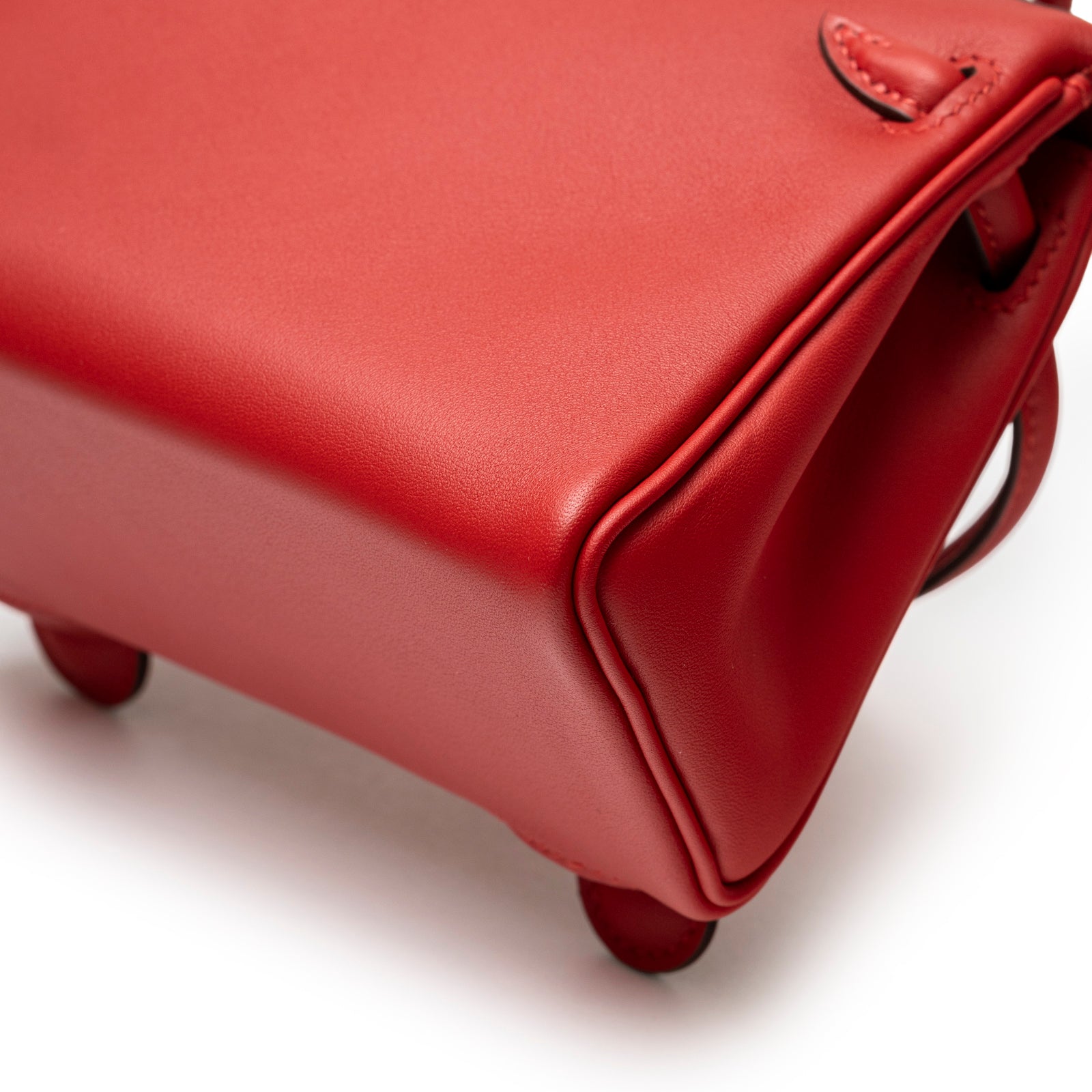 Close-up angled view of red smooth leather corner on Hermès Quelle Idolle Kelly Doll Rouge Radieux Rouge H Swift Palladium Hardware