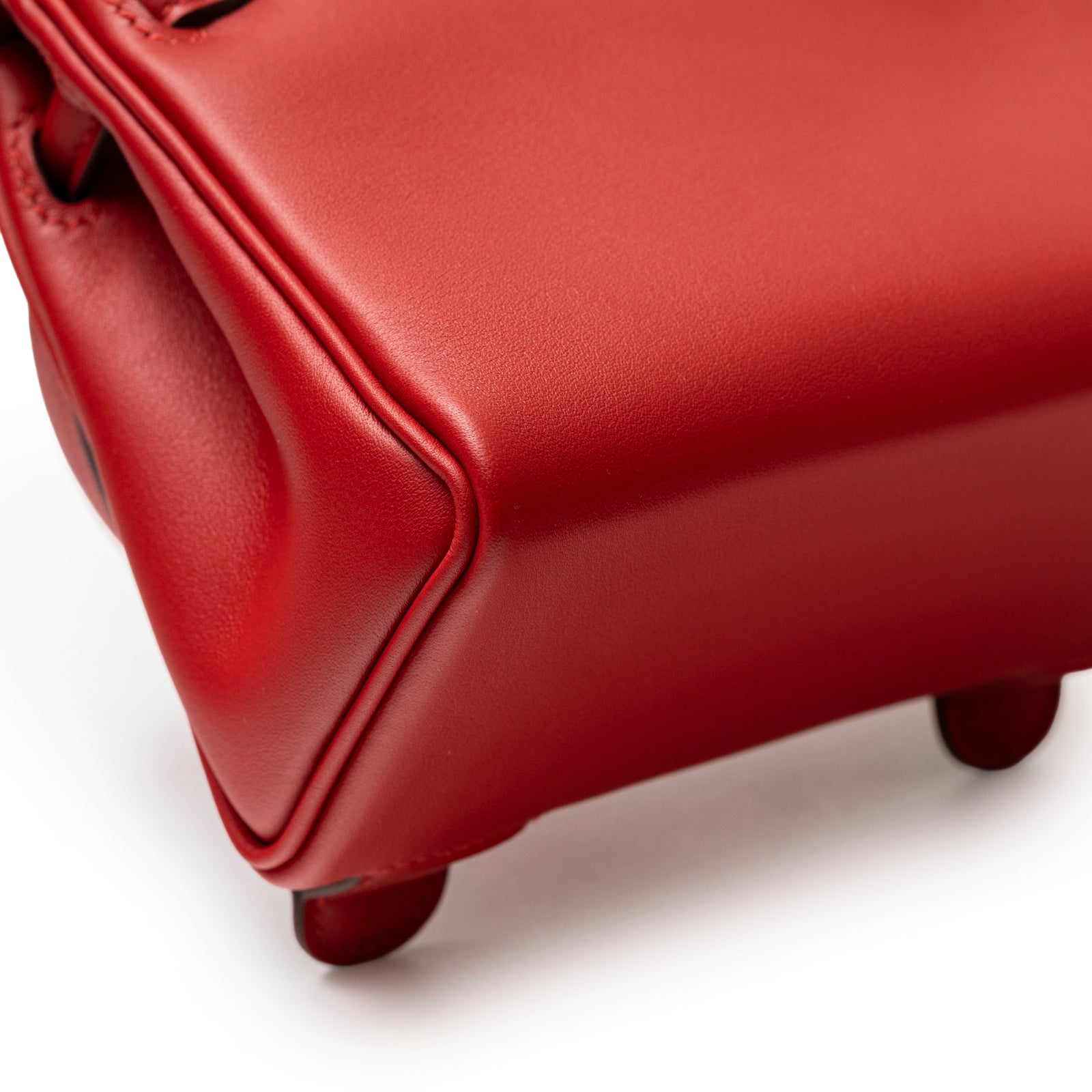 Close-up angled shot of the corner and foot of Hermès Quelle Idolle Kelly Doll Rouge Radieux Rouge H Swift Palladium Hardware.