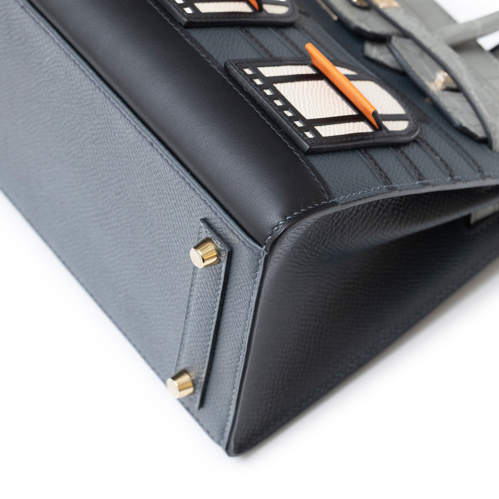 Close-up angled shot of Hermès Sac Faubourg Birkin 20 "Rainy Days" Gris Misty Matte Alligator Permabrass Hardware base detail