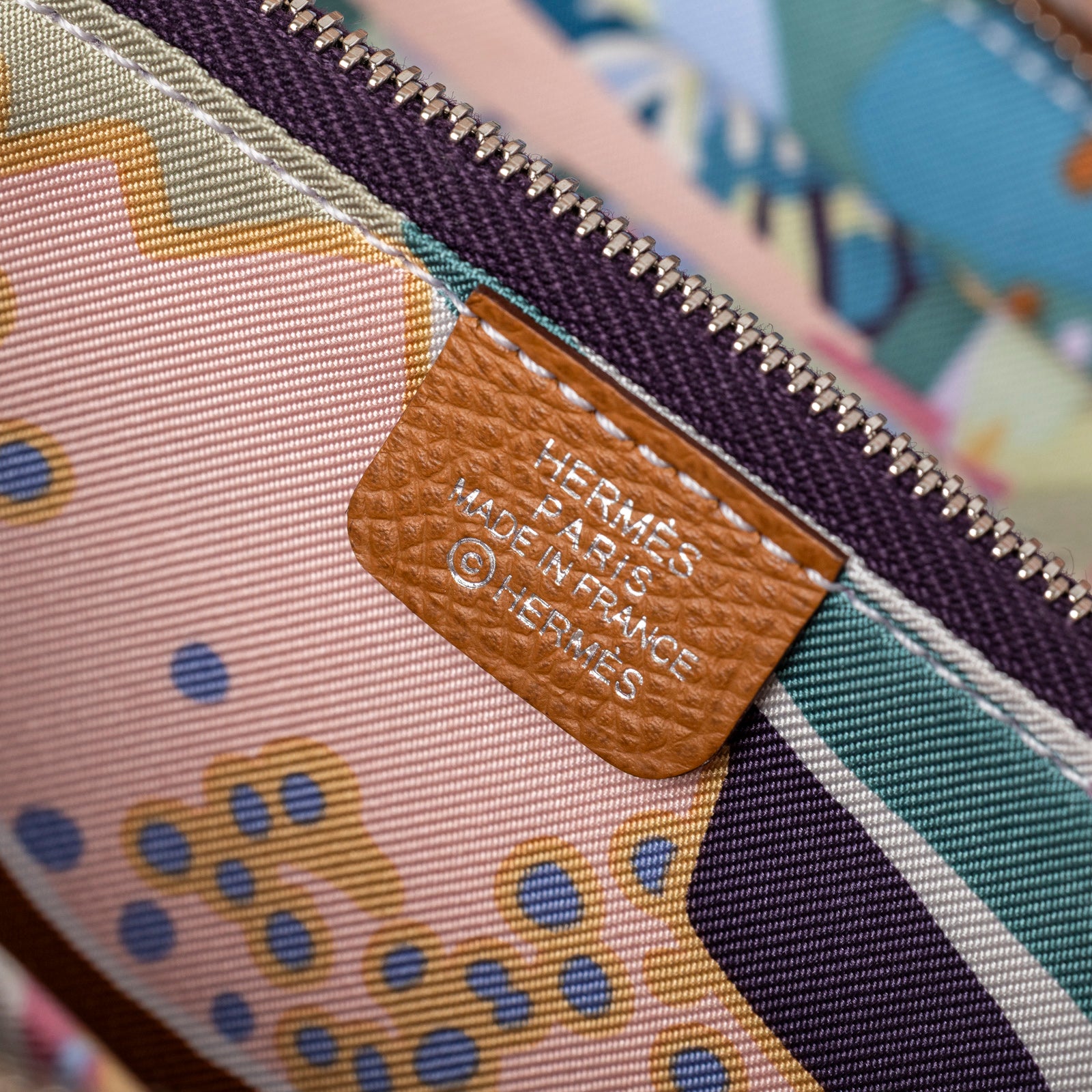 Close-up of interior label on Hermès Silk'In Compact Wallet Gold Cassis Vert Fizz Epsom Palladium Hardware showing stitching and fabric pattern detail
