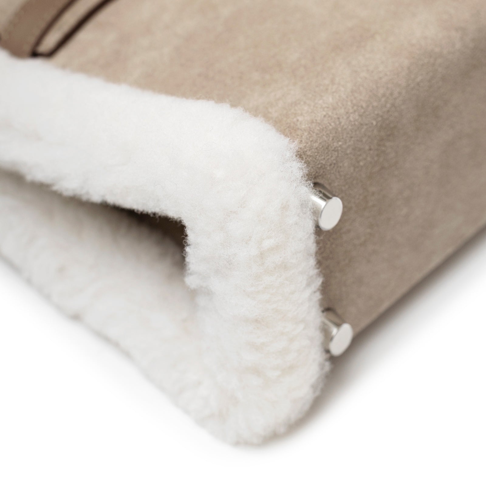 Close-up of Hermès Teddy Mini Kelly II Gris Caillou Etoupe Grizzly Swift Palladium Hardware showing soft shearling trim and metal studs.