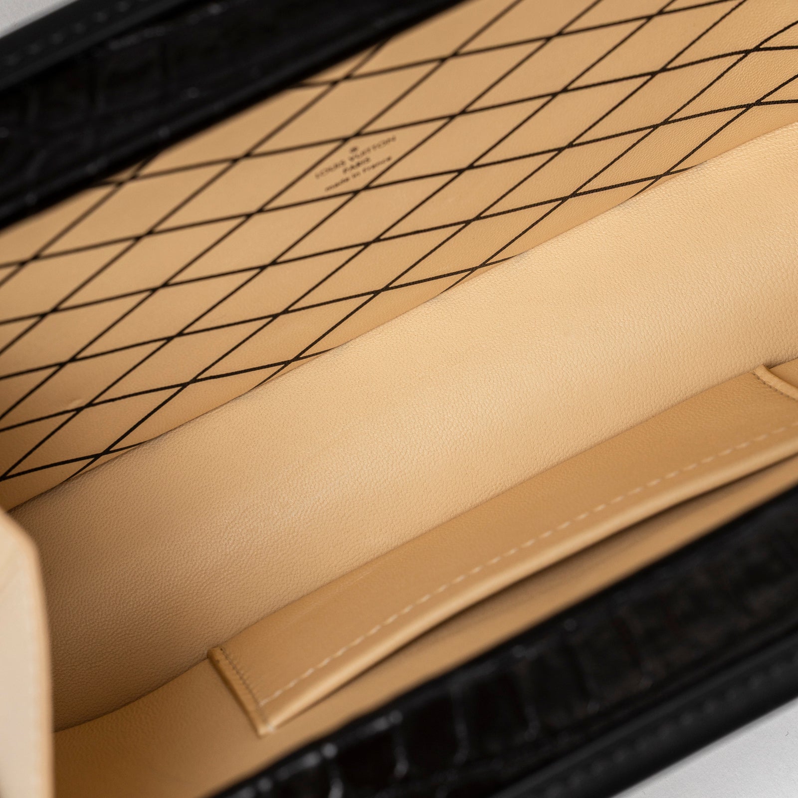 Interior view of Louis Vuitton Petite Malle Black Shiny Niloticus Gold Hardware with beige leather lining and stitching detail