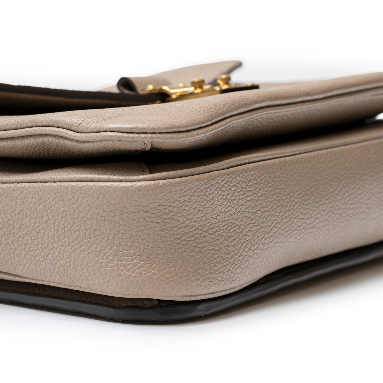 Close-up angled view of Louis Vuitton Pochette Métis Monogram Empreinte Turtledove Gold Hardware showing textured leather and edge detail