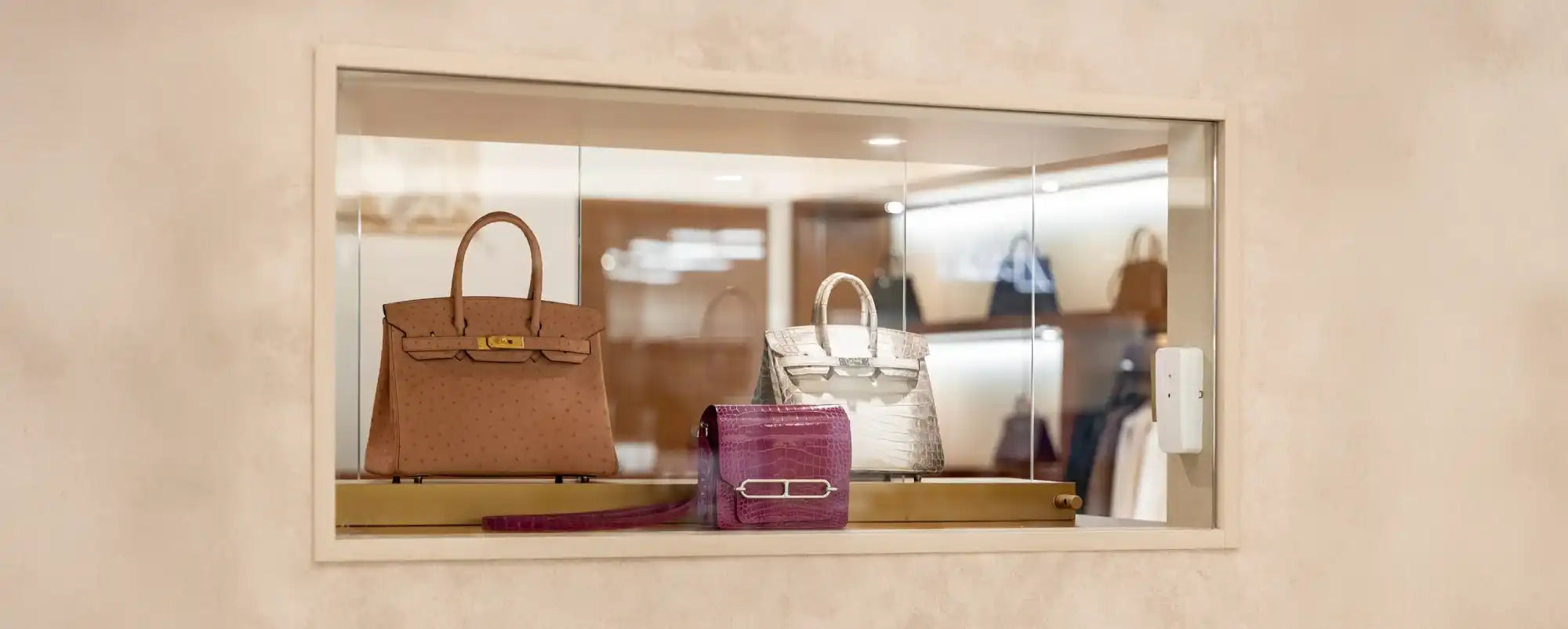 Luxury handbags in display case.