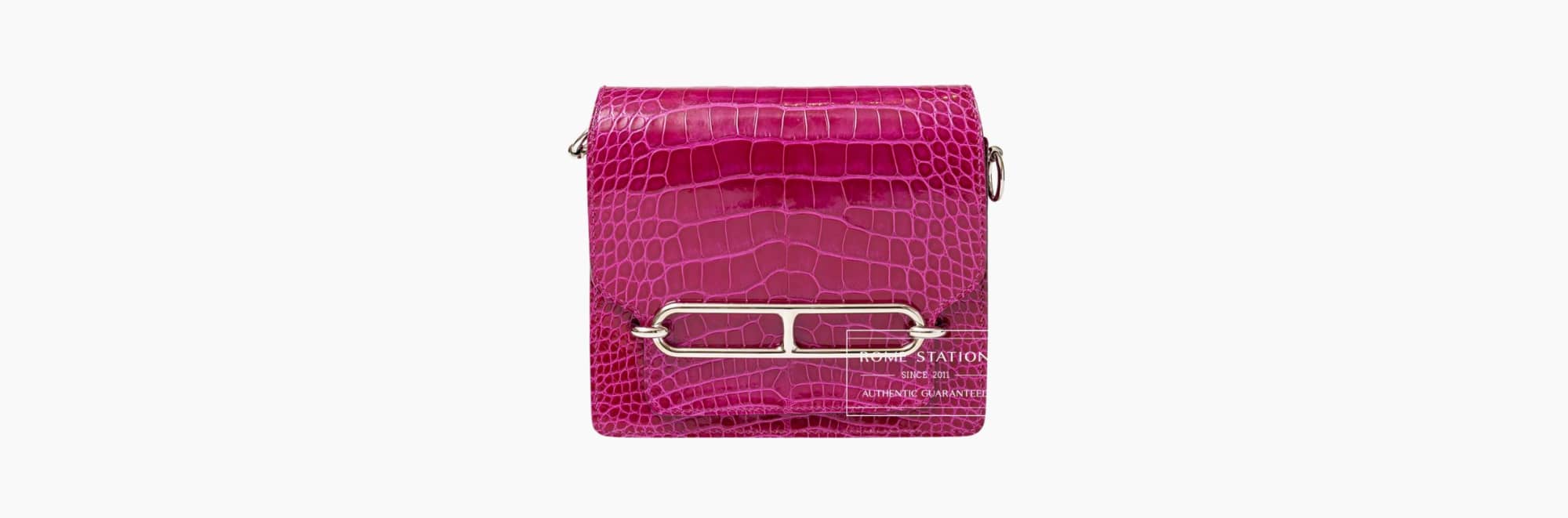 Pink crocodile-patterned handbag with silver clasp.
