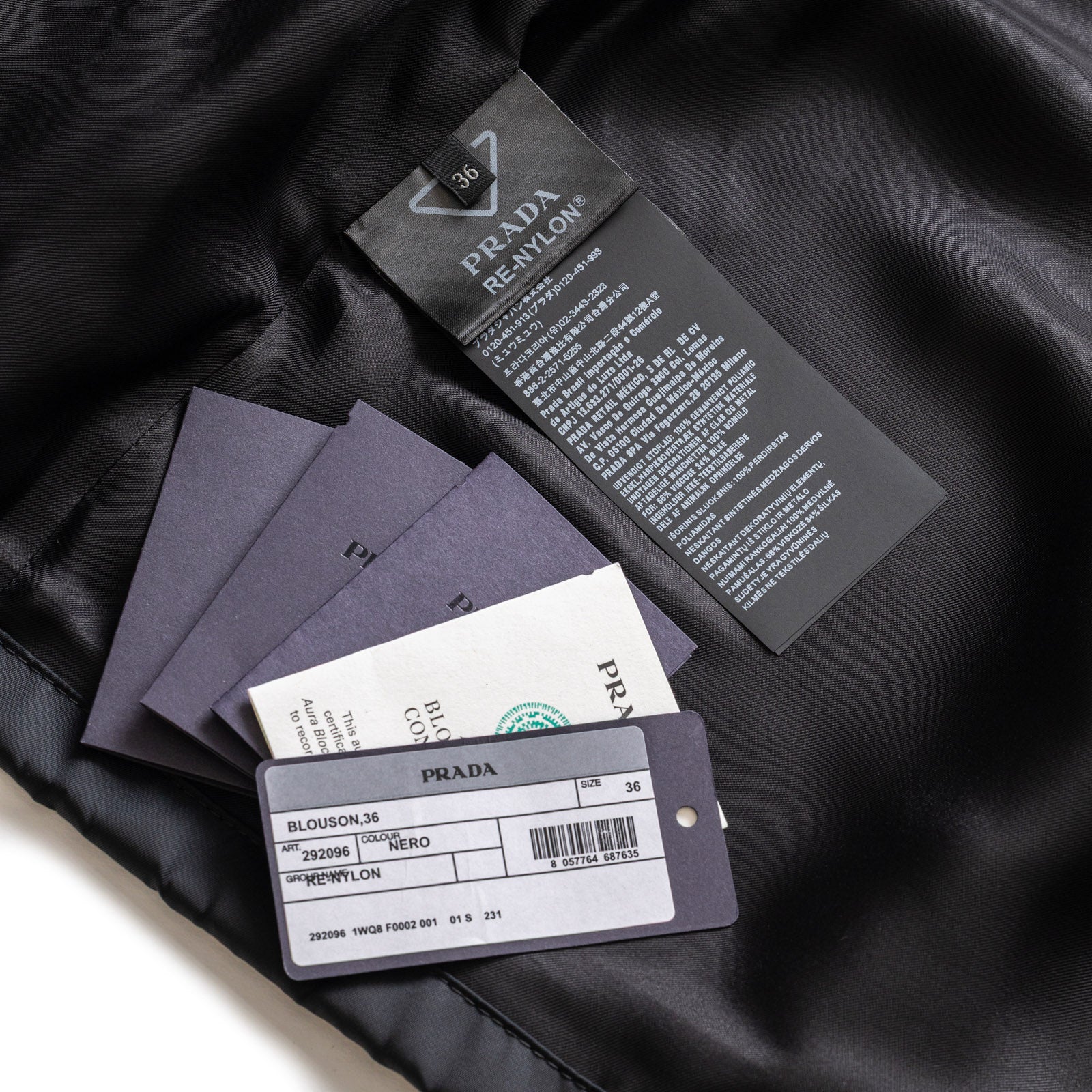 Close-up of Prada Re-Nylon Jacket Crystal Buttoned Black/White inner lining with size and care tags visible