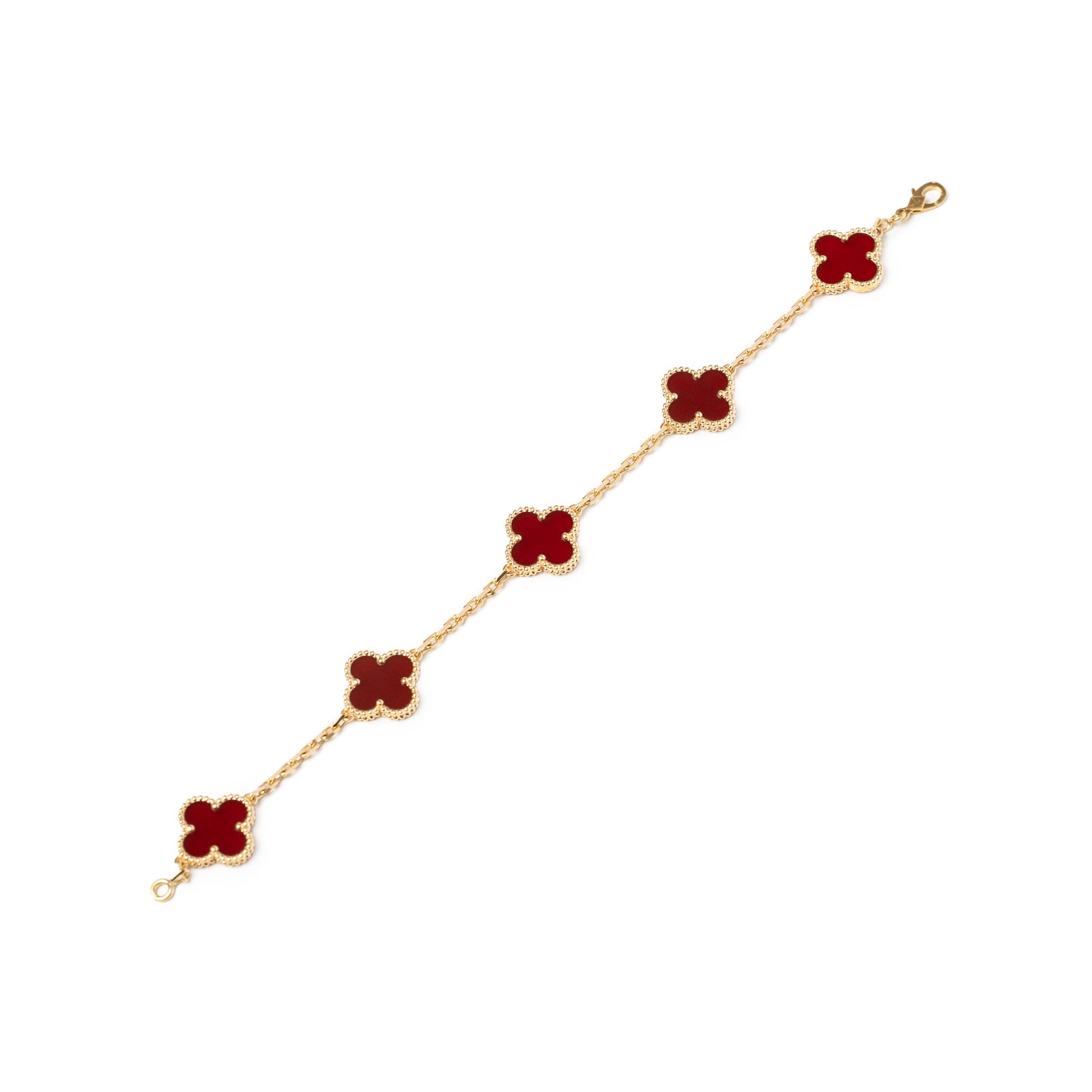 Flat lay of Van Cleef & Arpels Vintage Alhambra 5 motifs Bracelet 18K Yellow Gold Carnelian showing red clover-shaped motifs and gold chain links.
