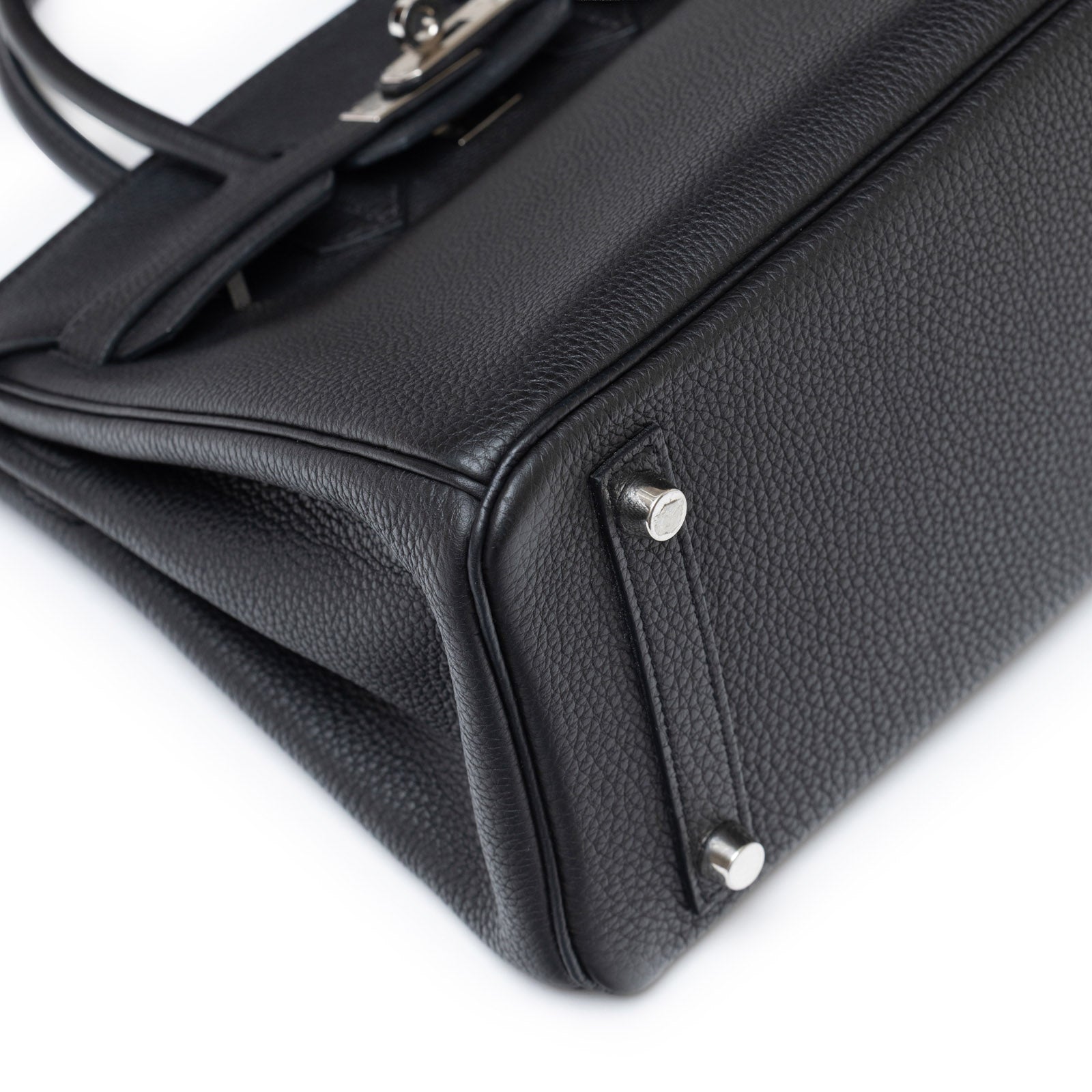 Close-up bottom corner view of Hermès Birkin 25 Black Togo Palladium Hardware showing leather texture and feet details