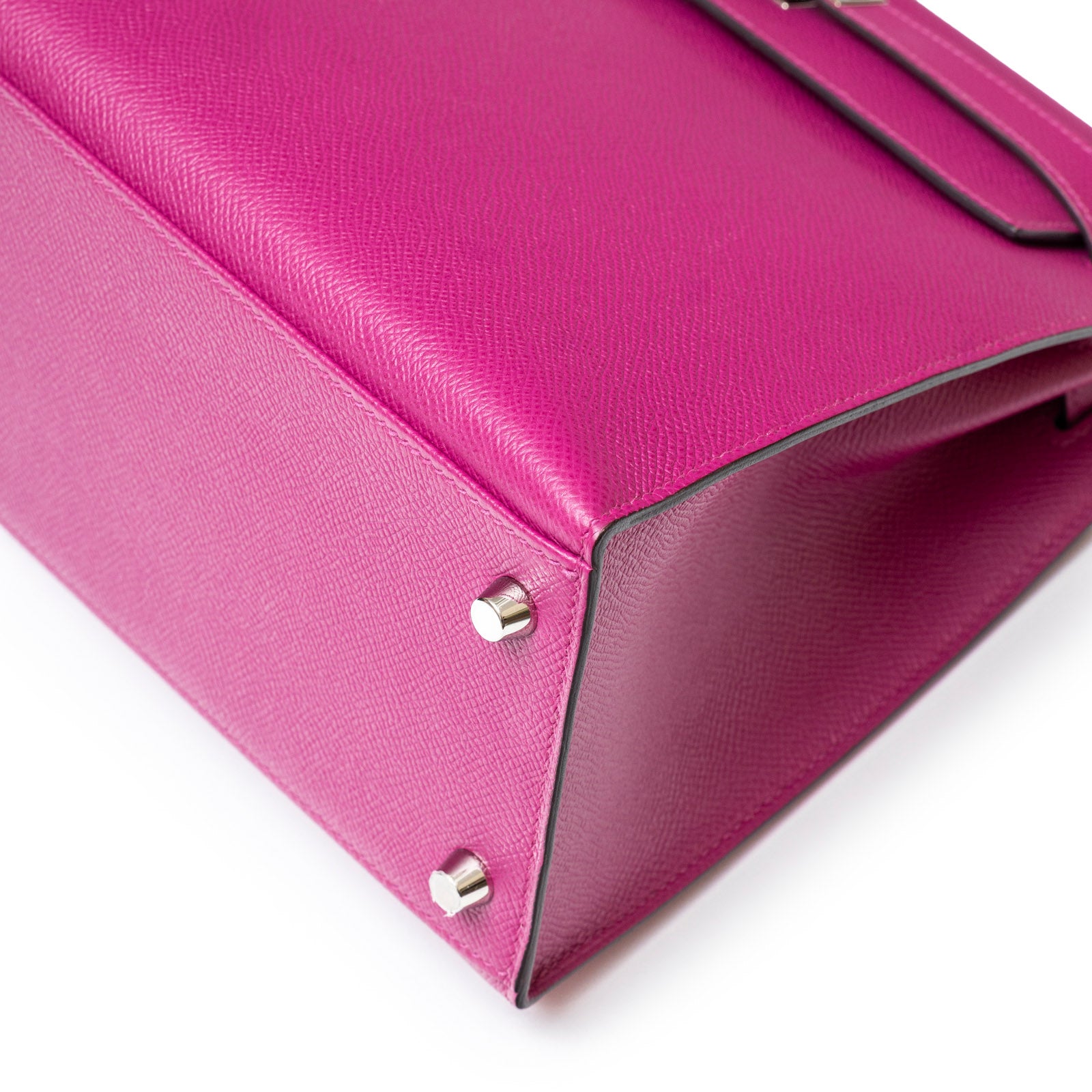 Hermès Kelly 28 Sellier Rose Pourpre handbag base with silver-tone studs, angled close-up view.