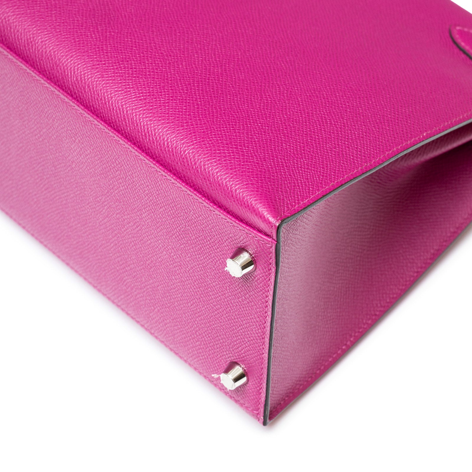 Bottom view of a Hermès Kelly 28 Sellier Rose Pourpre with silver studs and textured leather finish.