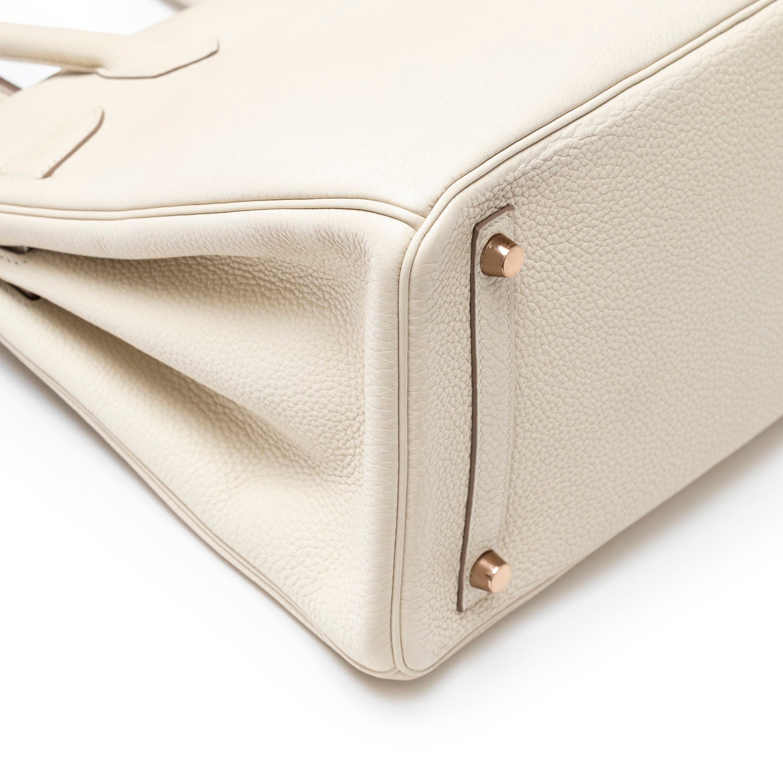 Close-up bottom view of Hermès Birkin 30 Craie Togo Rose Gold Hardware showing leather texture and studs detail