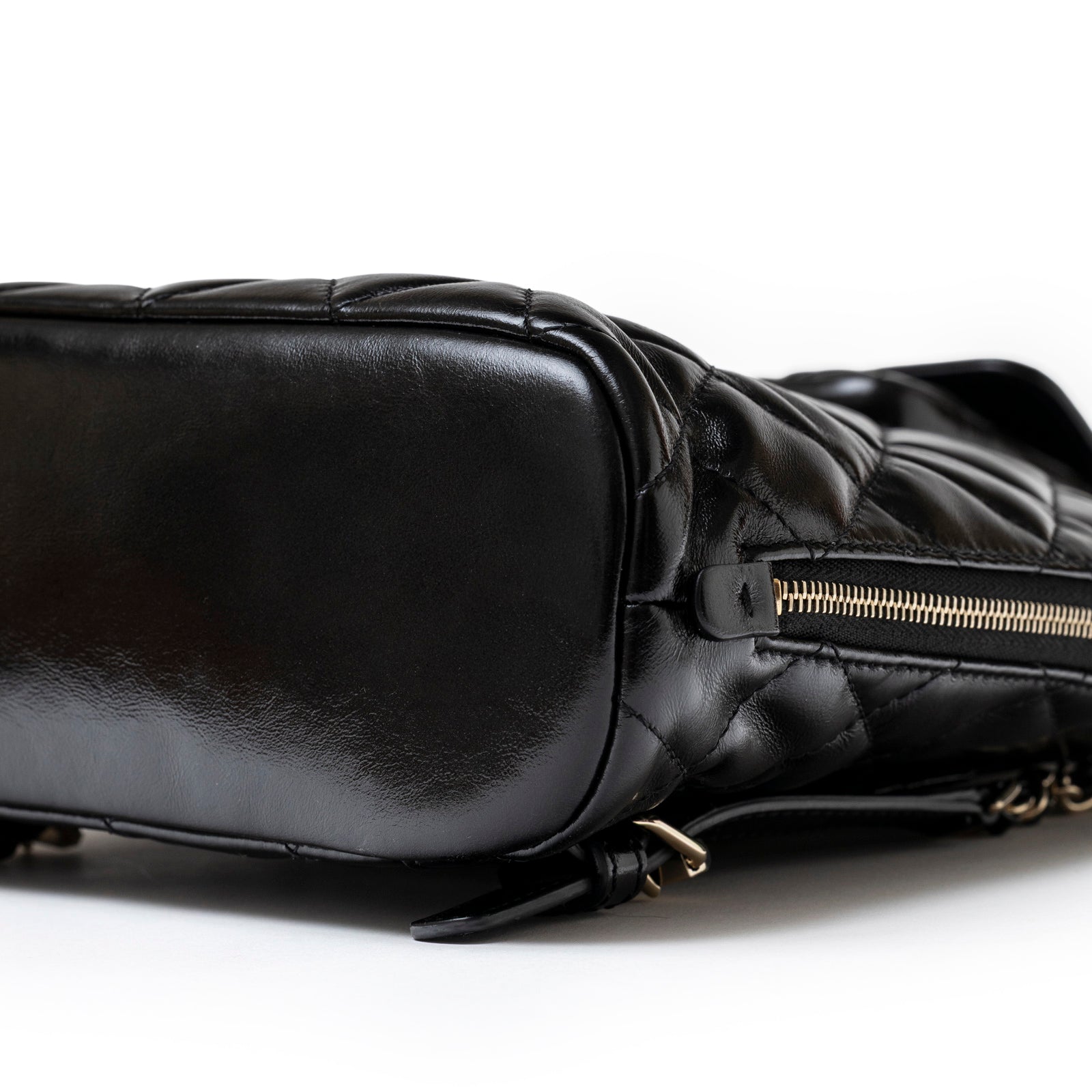 Close-up bottom view of Chanel My Pocket Backpack Black Shiny Calfskin Gold Hardware showing base and zipper detail