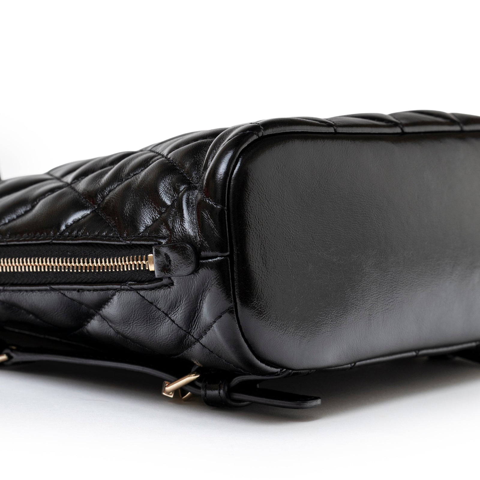Close-up bottom view of Chanel My Pocket Backpack Black Shiny Calfskin Gold Hardware showing smooth leather and gold zipper detail