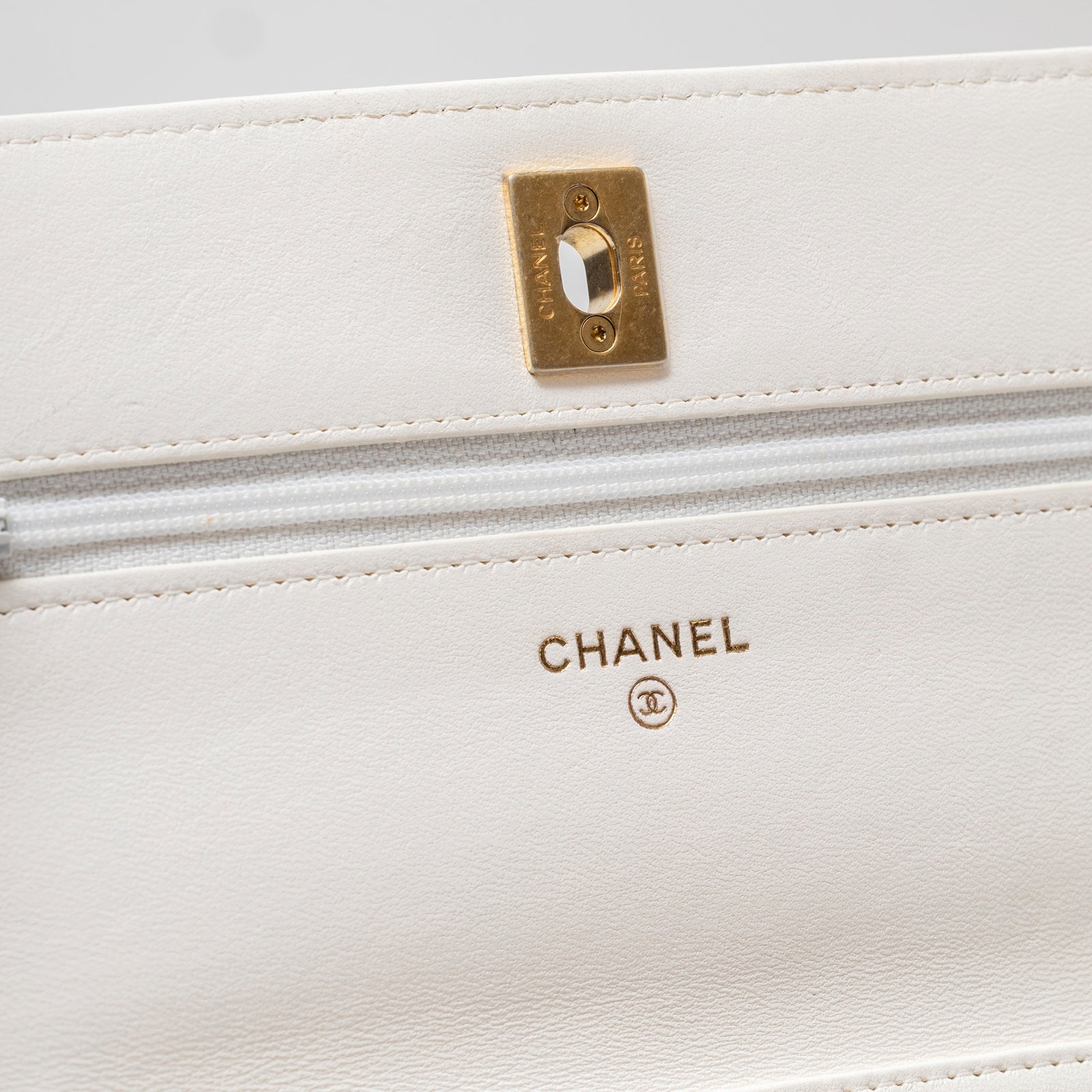 Close-up interior view of Chanel CC Pearl Crush Wallet on Chain WOC Quilted Lambskin White Brushed Gold Hardware showing logo and zipper detail