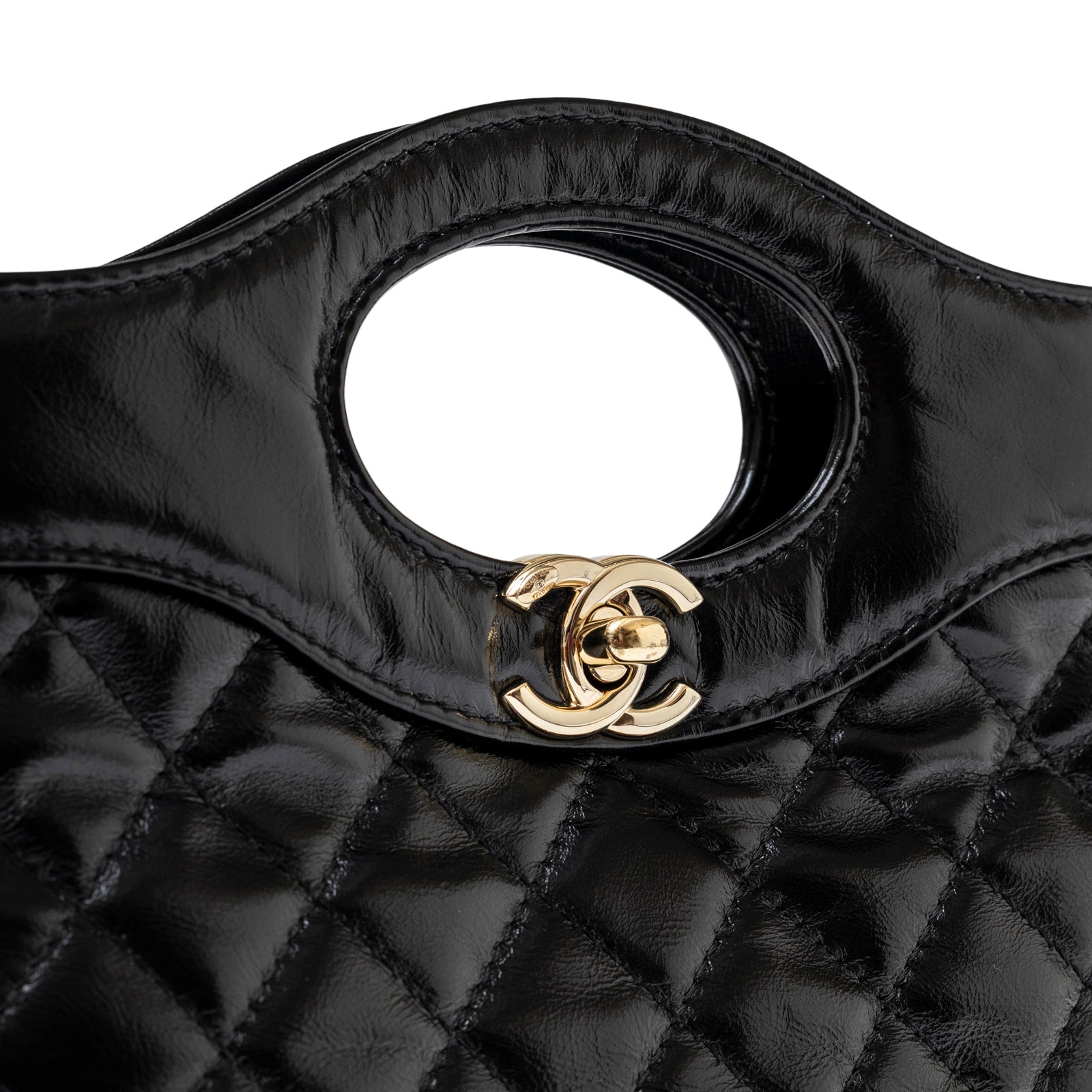 Close-up of black calfskin quilting and gold clasp on Chanel Mini 31 Shopping Tote Calfskin Black Gold Hardware
