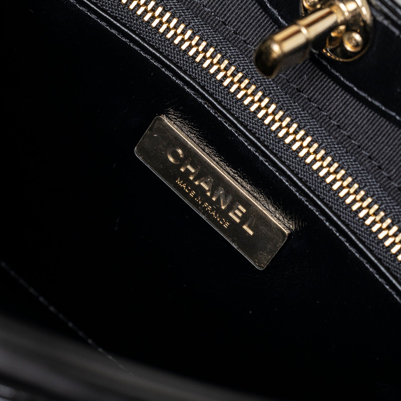 Close-up of interior label and gold hardware on Chanel Mini 31 Shopping Tote Calfskin Black Gold Hardware