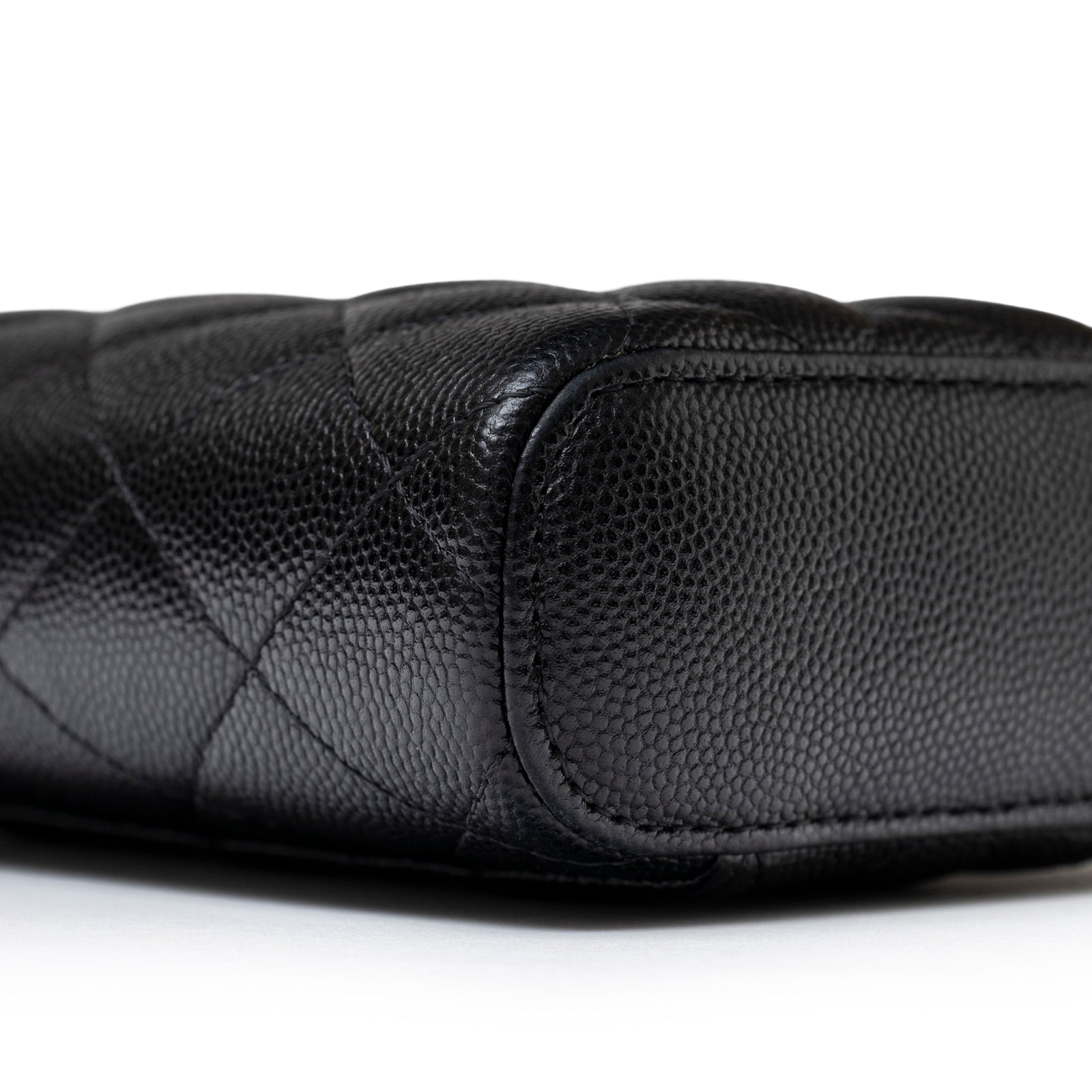 Close-up of the bottom corner showing textured black caviar leather on Chanel Mini Coco Beauty Vanity Case on Chain Black Caviar Gold Hardware
