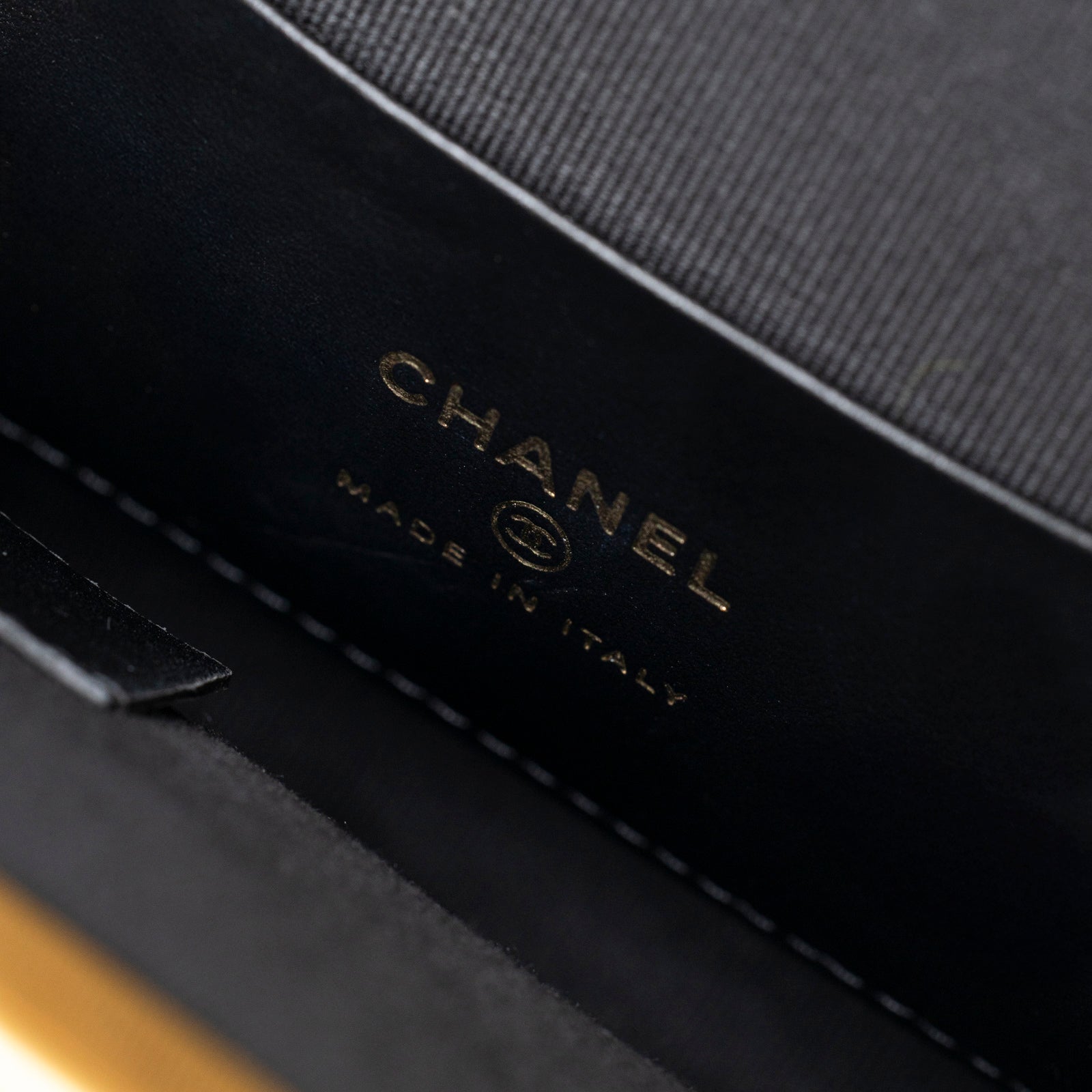 Close-up interior view of Chanel Maxi Bow Clutch With Chain Black/Pink Shiny Quilted Patent showing logo and stitching details