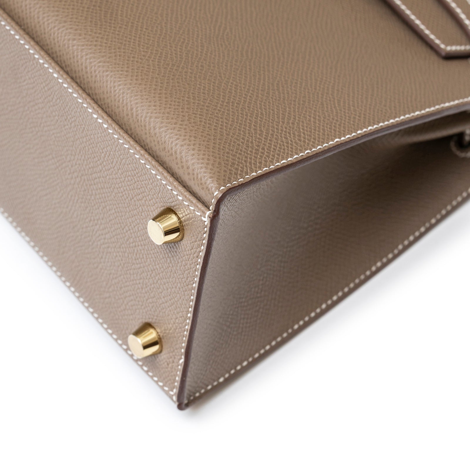Close-up of corner and gold hardware feet on Hermès Kelly 25 Sellier Etoupe Epsom Gold Hardware handbag