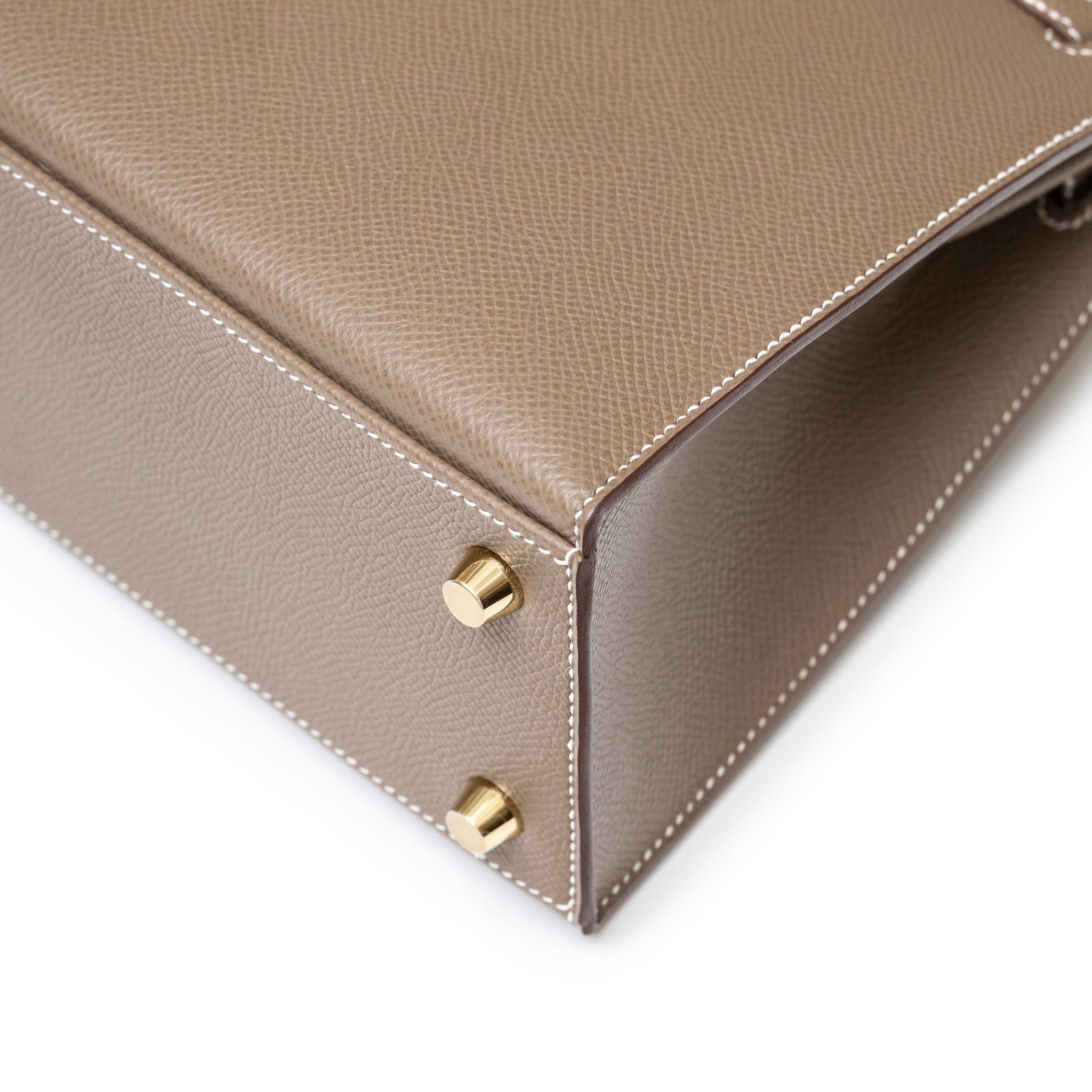 Close-up of bottom corner and gold hardware feet on Hermès Kelly 25 Sellier Etoupe Epsom Gold Hardware leather bag