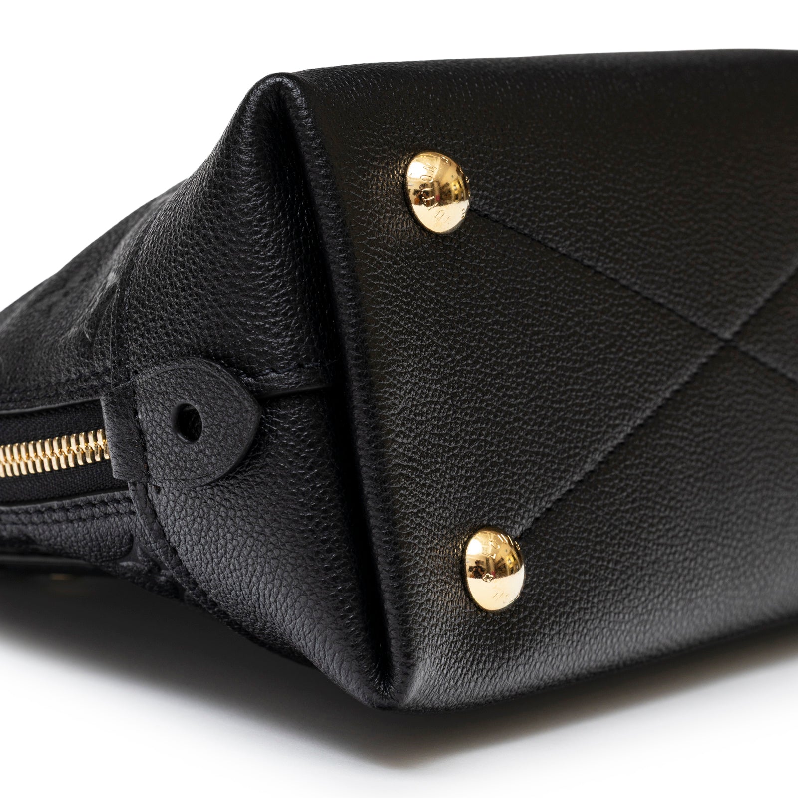 Close-up angled shot of Louis Vuitton Neo Alma BB Monogram Empreinte Black Gold hardware base with textured leather
