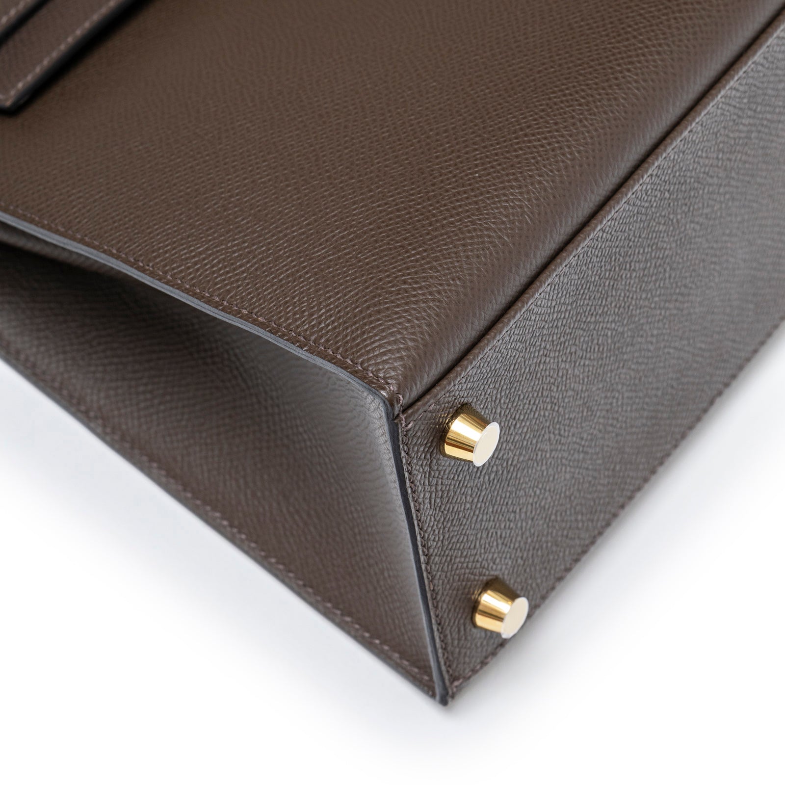 Close-up of base corner and gold hardware on Hermès Kelly 25 Sellier Ecore Epsom Gold Hardware bag