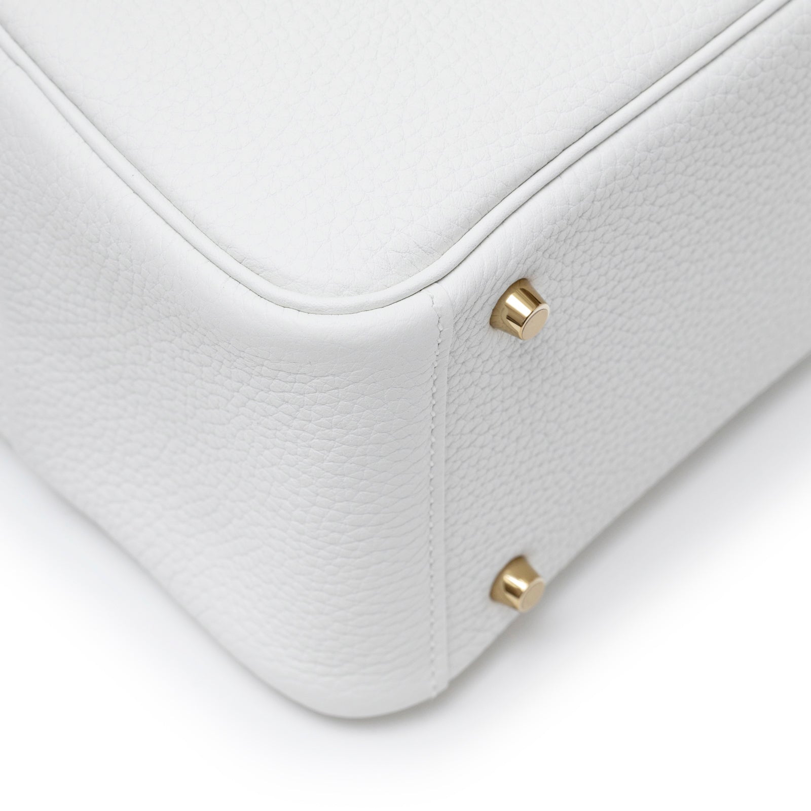 Close-up of white Clemence leather corner and gold hardware studs on Hermès Mini Lindy II New White Clemence Gold Hardware